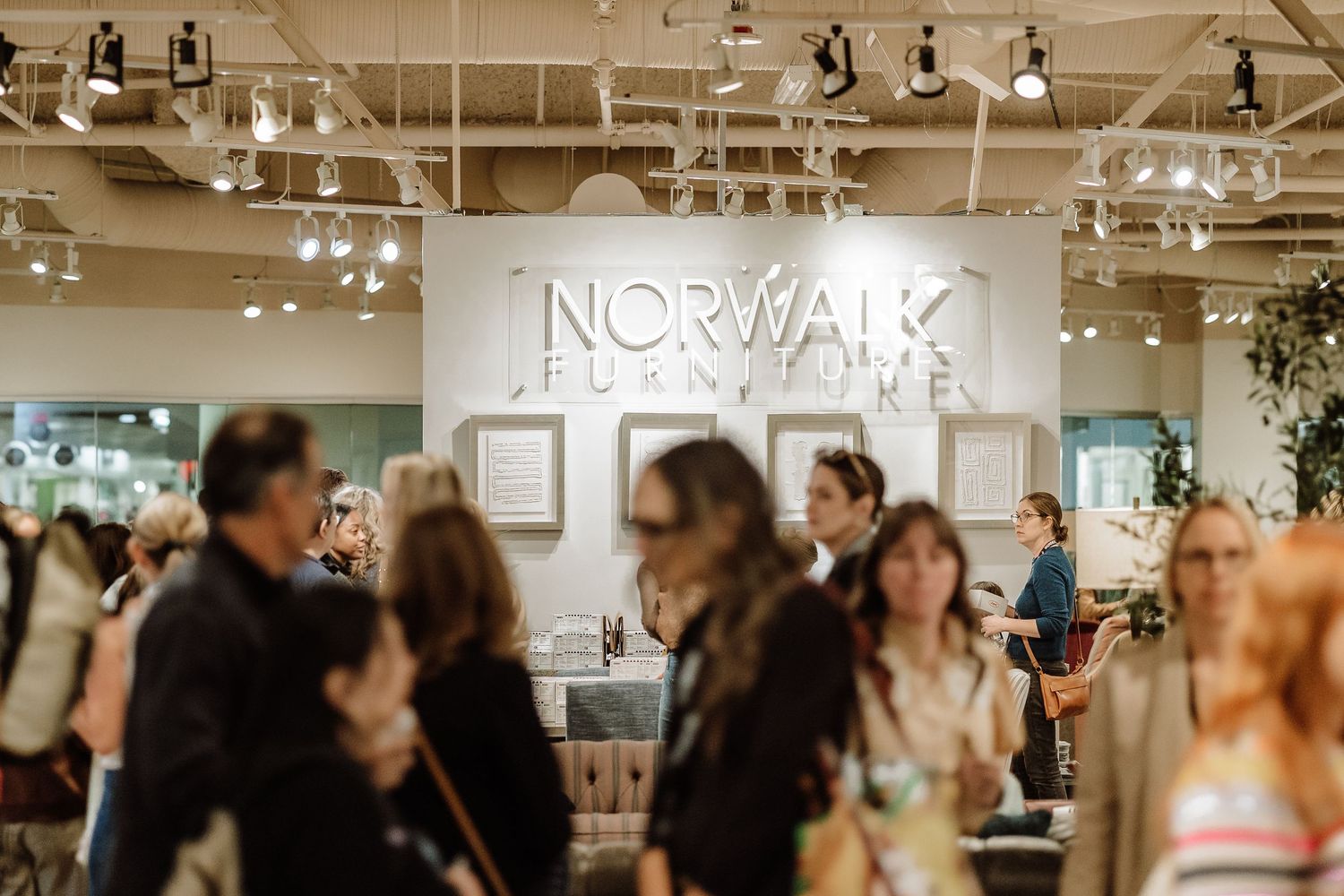 Attendees browse displays at a busy Norwalk Furniture trade show event.
