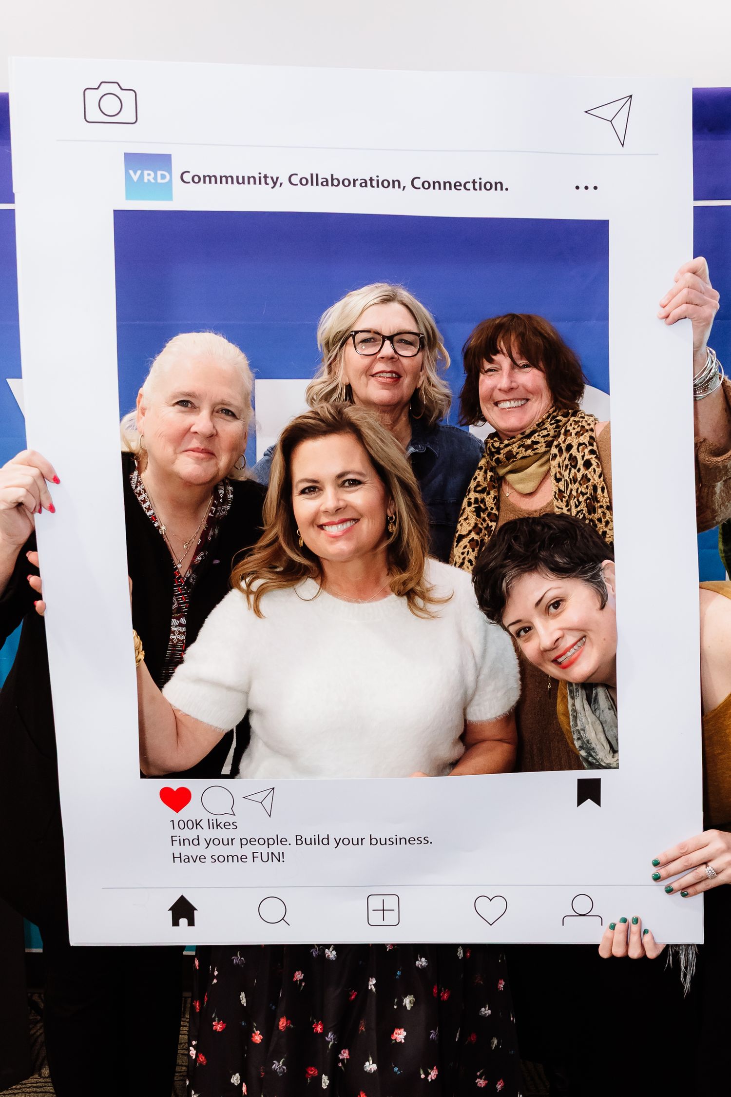 Five women pose inside a decorative social media frame at a YBD community event.