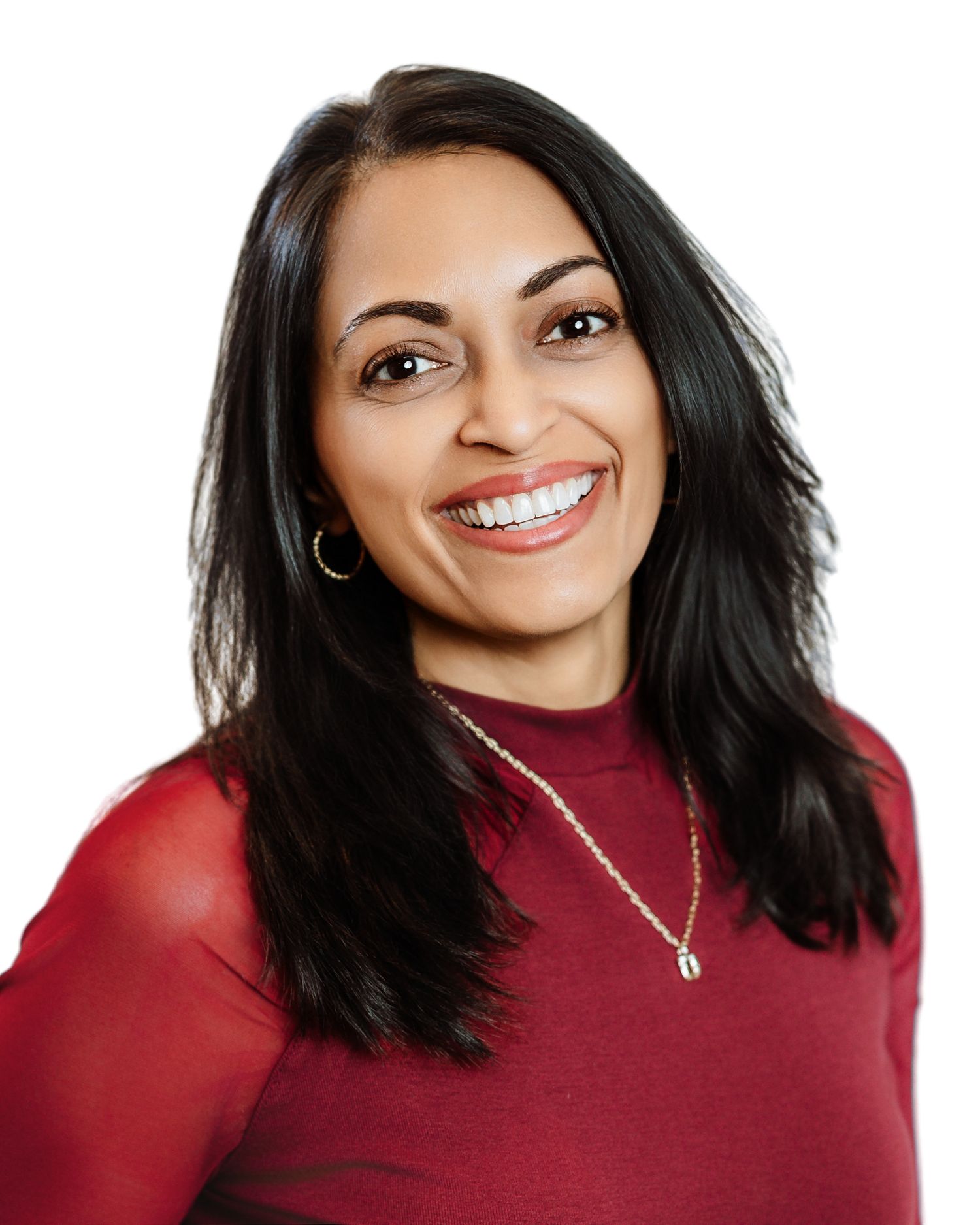 Smiling woman with dark hair wearing red top and gold necklace against clean white background.