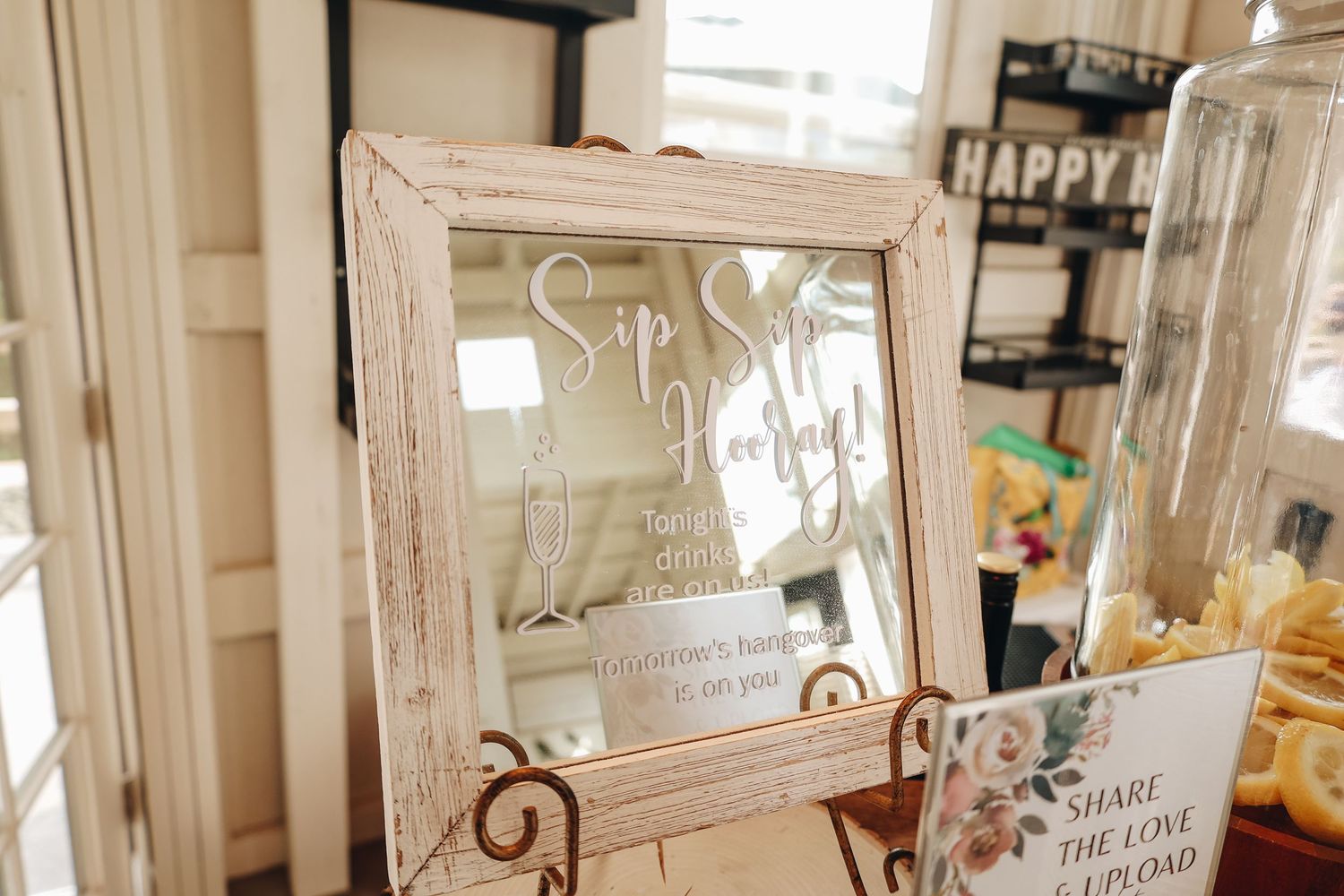 Elegant mirror sign reading Sip Sip Hooray on ornate easel at a wedding bar station display.