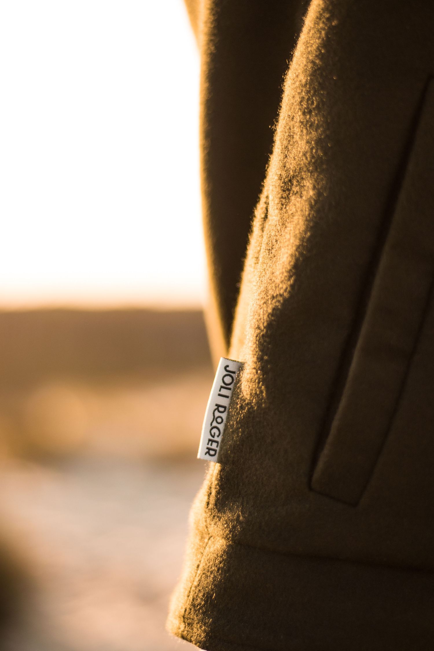 Plan détaillé en gros plan d'une étiquette de veste brune à la lumière dorée du soleil.