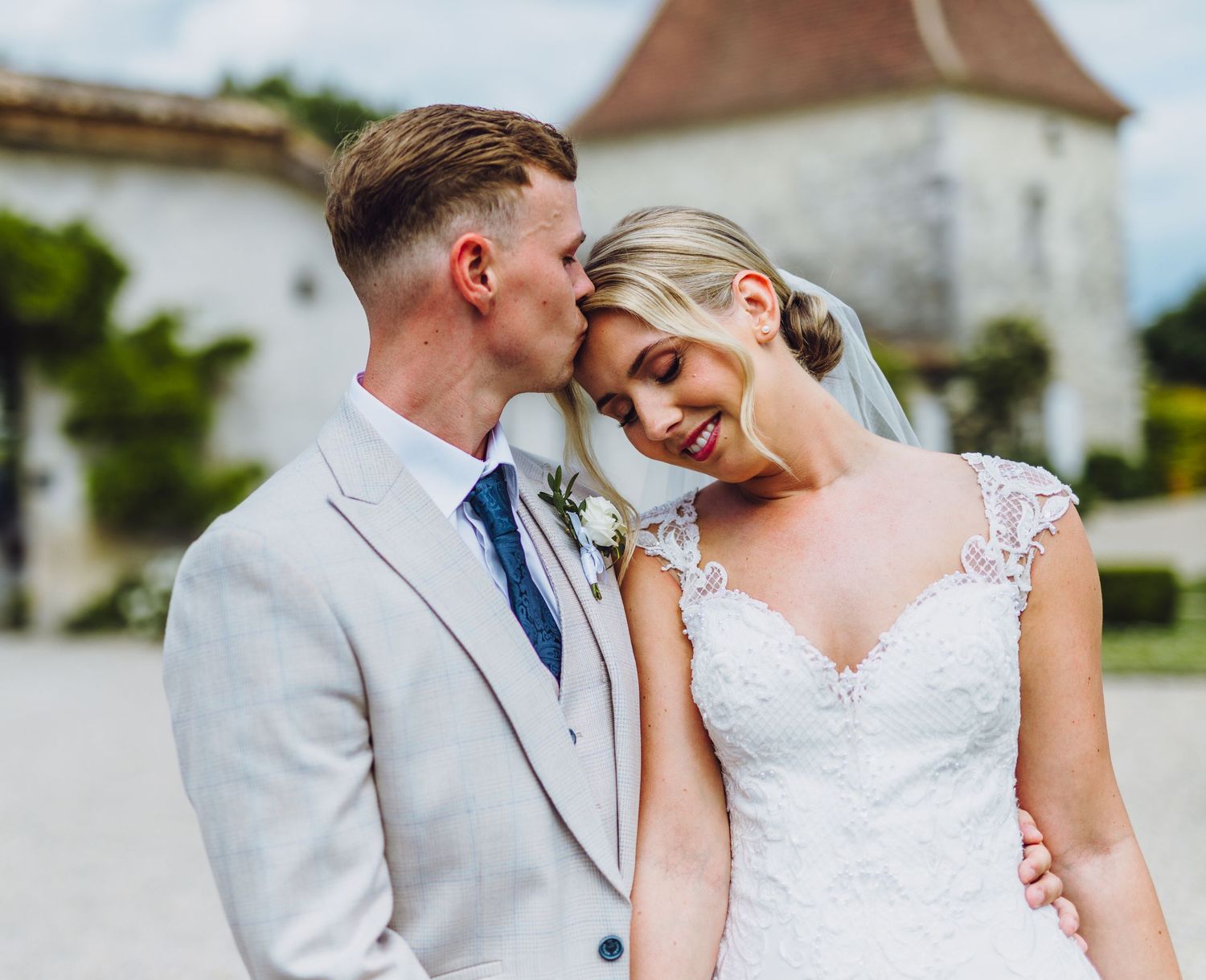 A romantic wedding couple shares intimate moments in a series of tender poses against an elegant outdoor backdrop.