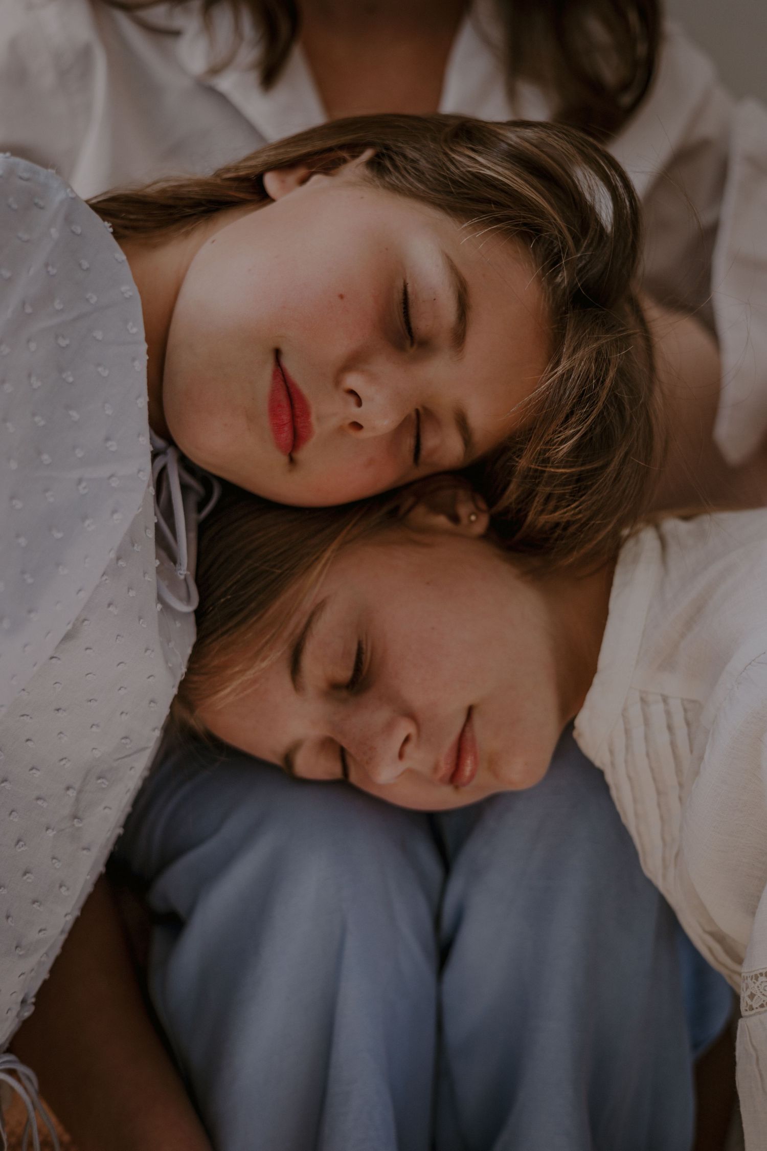 Two girls resting heads on mothers lap, intimate motherhood in Norfolk,colour,natural light, muted tones