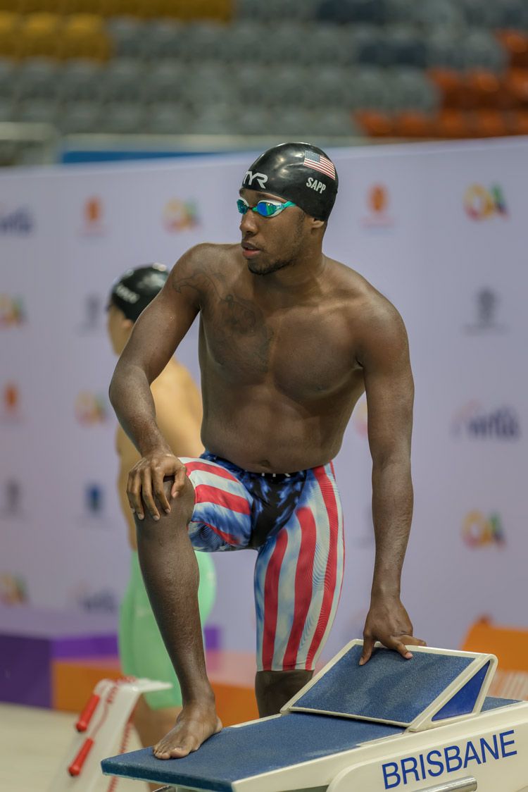 Nick Wigmore Photography - Male USA swimmer on starting blocks before a swimming race.