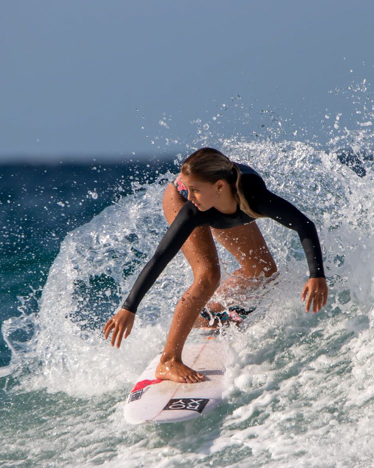 Surfer chick riding a wave in the sun at Snapper Rocks, Queensland. Image by Nick Wigmore Photography