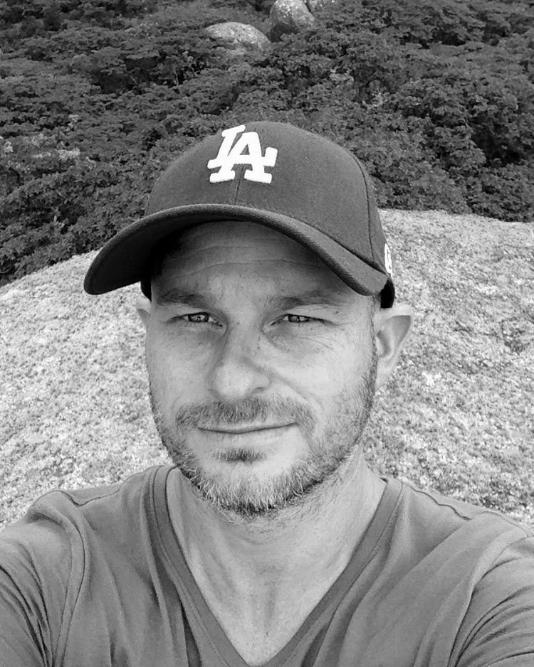 Person wearing LA Dodgers baseball cap in black and white selfie photo.