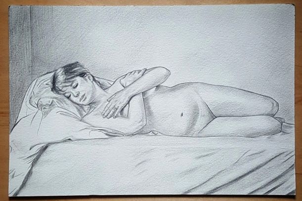 Artistic sketch of a reclining figure drawn in graphite pencil resting on a bed or couch.