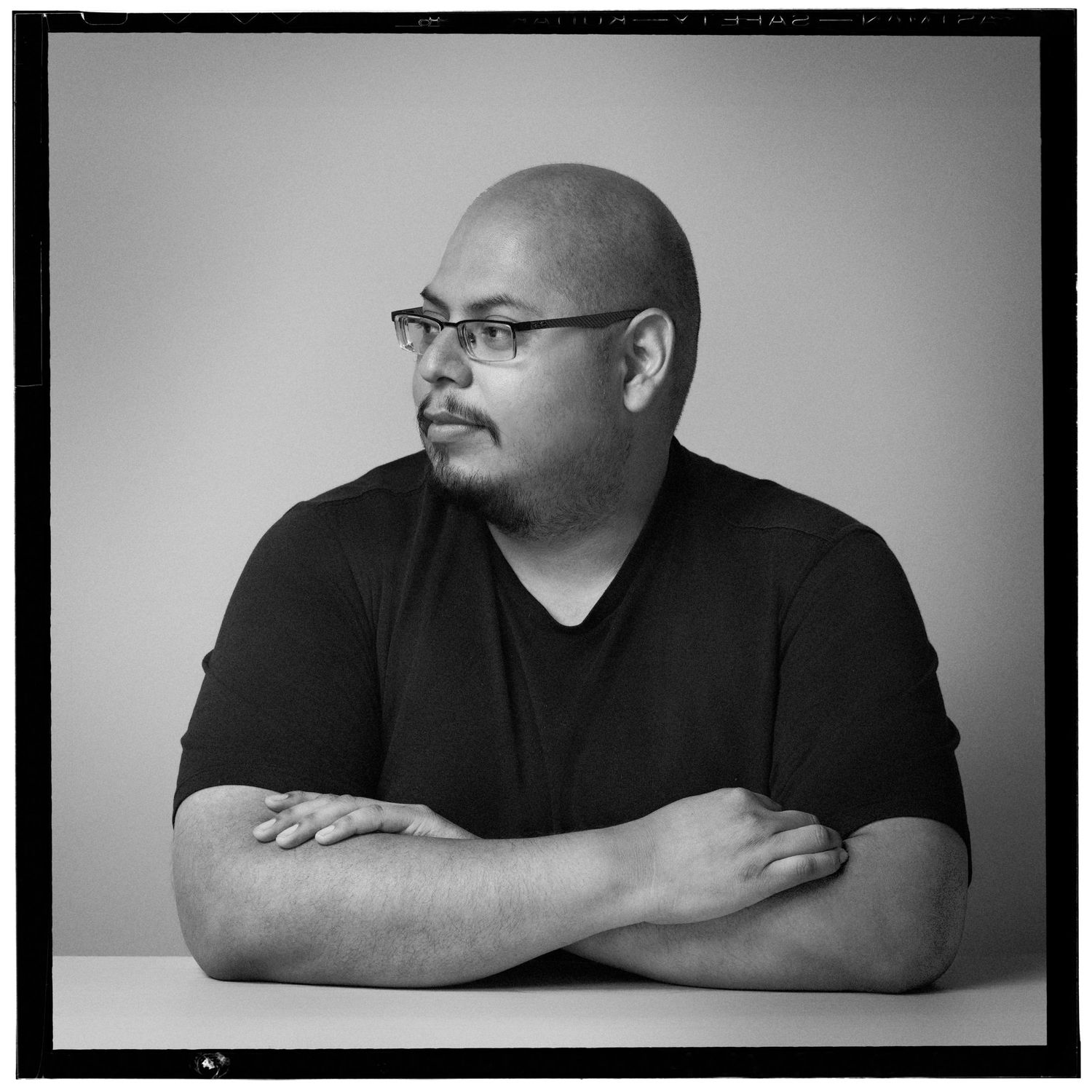 Black and white portrait series showing pensive side profile and resting poses against minimalist backgrounds.