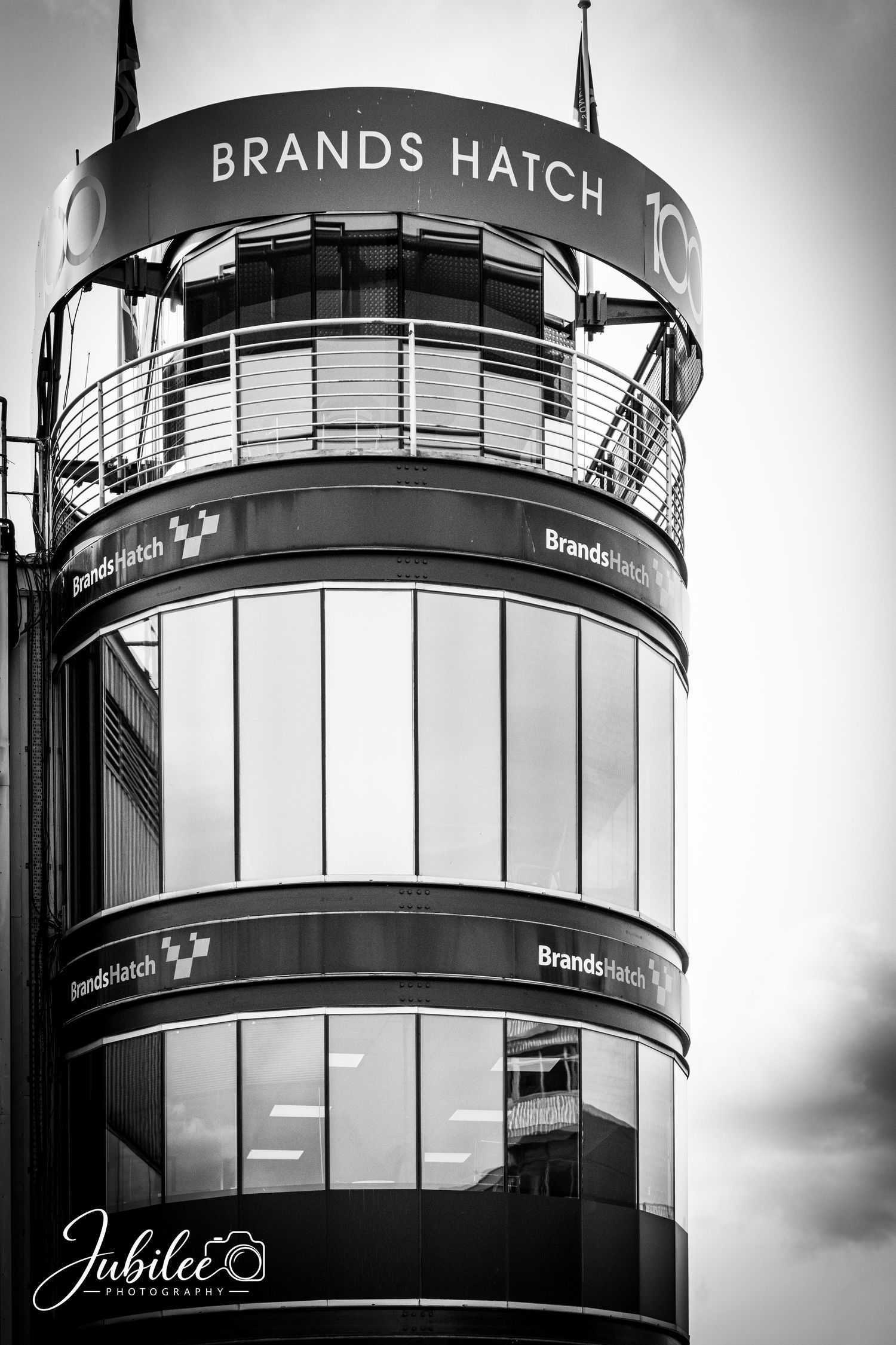 Black and white photo of the Brands Hatch racing circuit tower building with curved glass facade.
