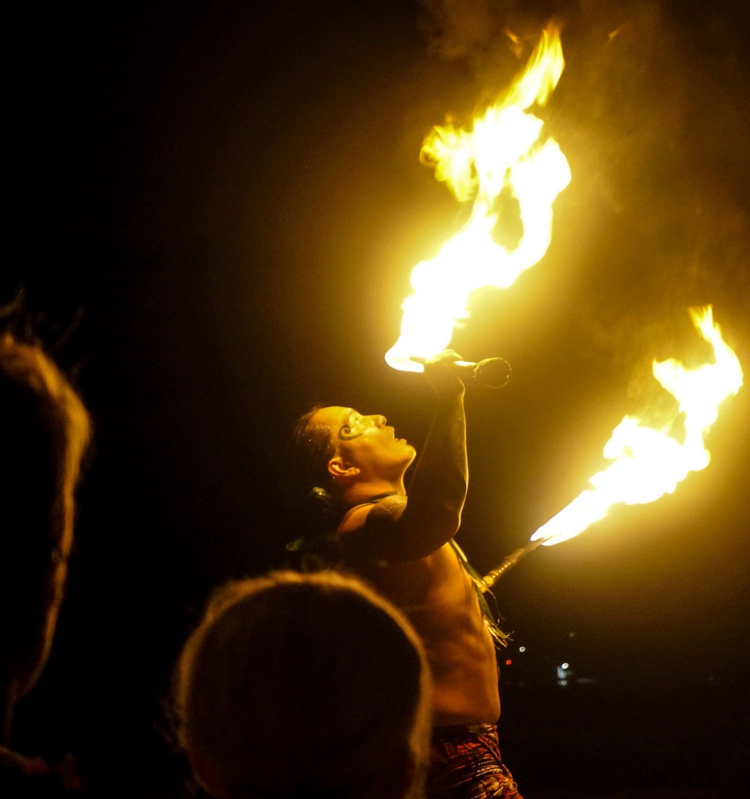 A firebreather inhales deeply before playing with fire.