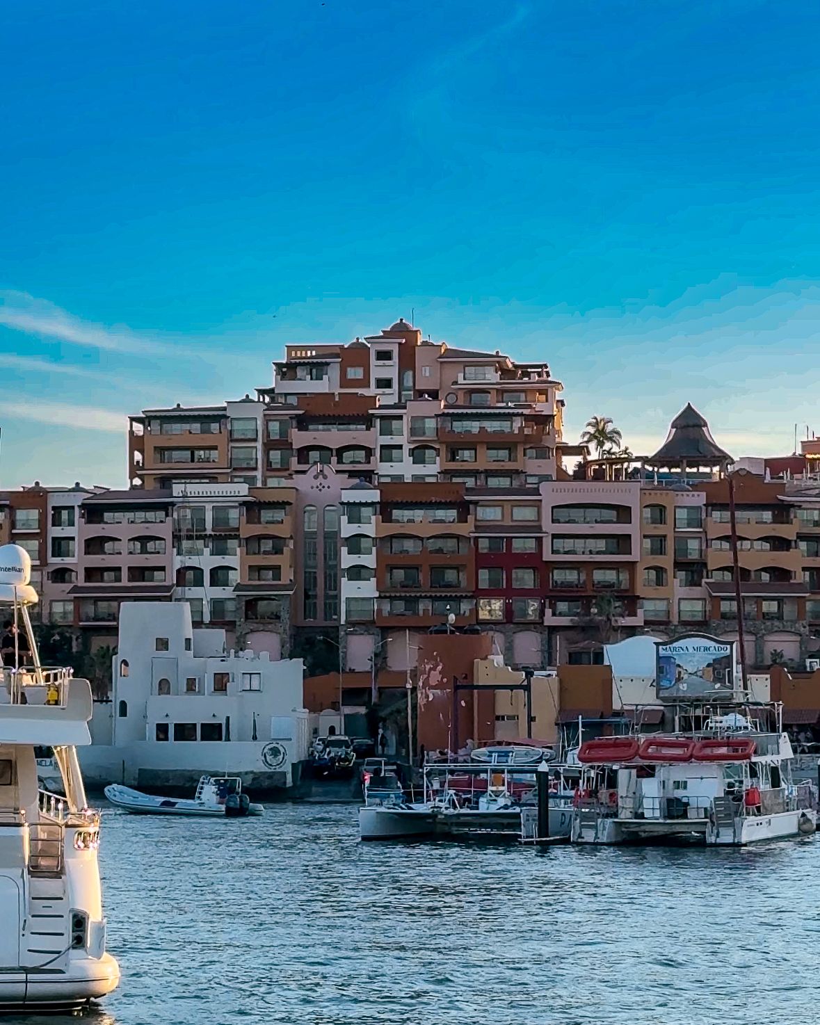 Bright boats anchored in front of colorful high-rise apartments.