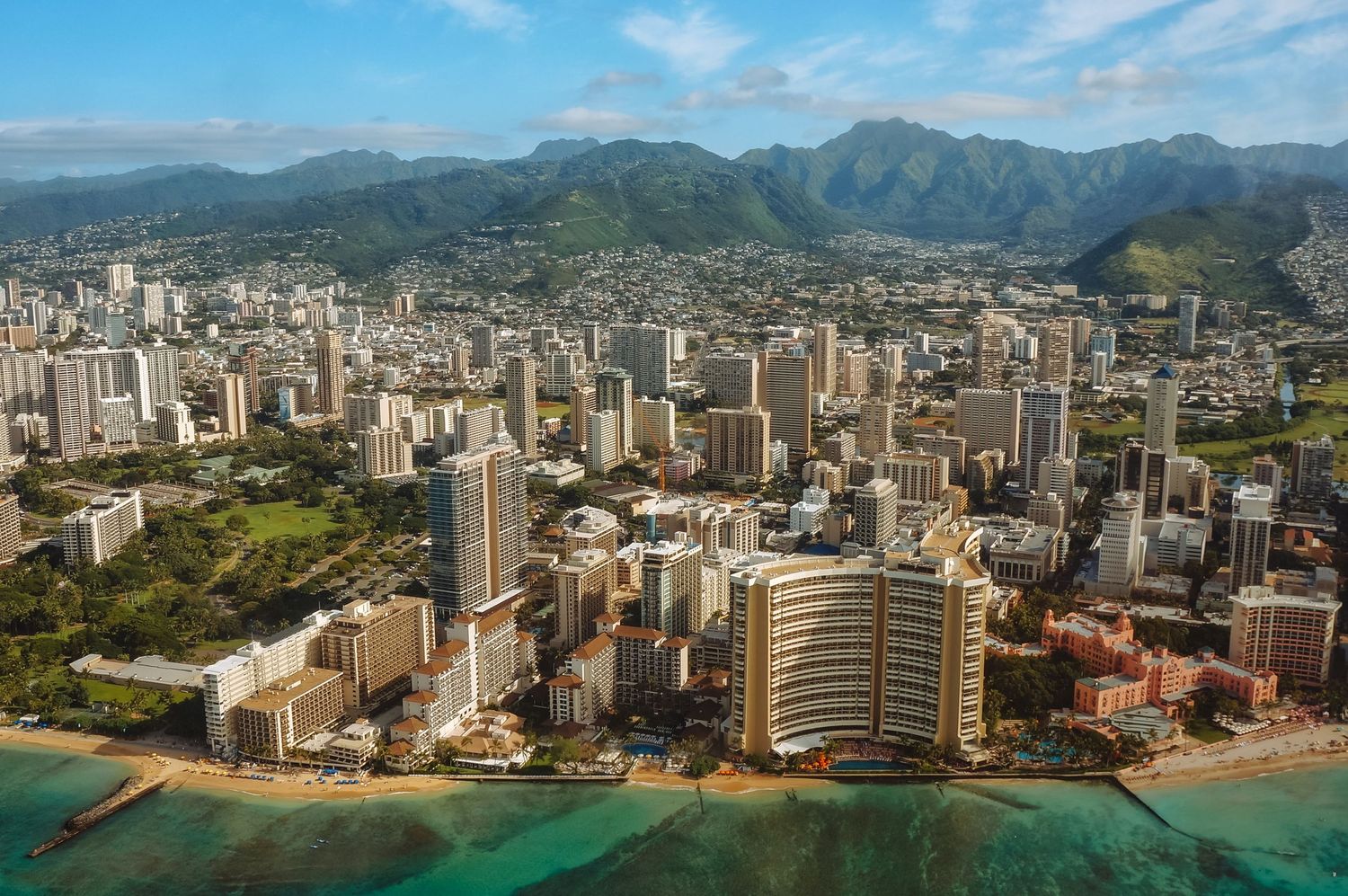 The Honolulu shoreline filled with hotels, photographed from the sky.