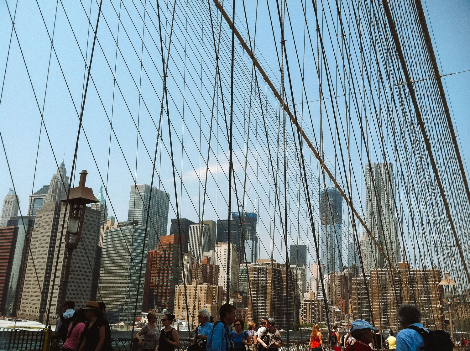 The New York skyline is seen through the cables of the Brooklyn Bridge.