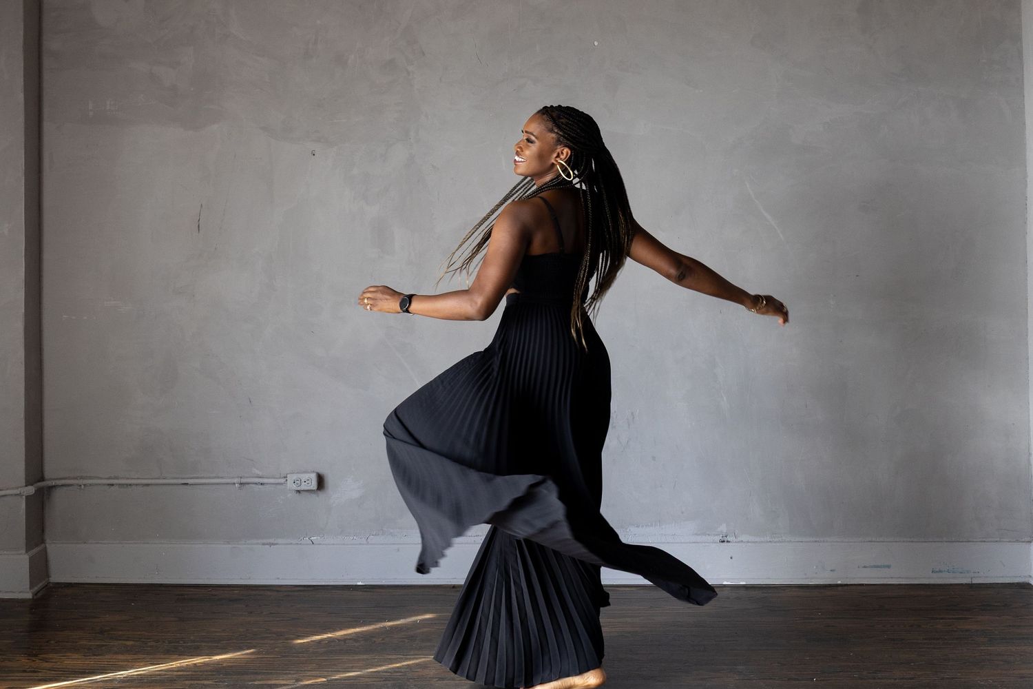 A woman twrils in a flowy black outfit.