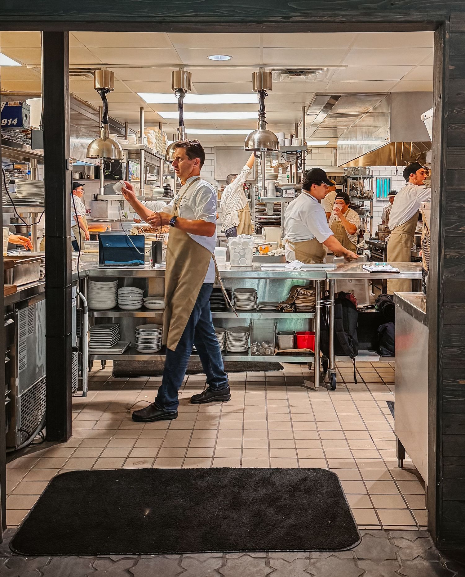 A chef gives orders in a very busy but very clean kitchen.