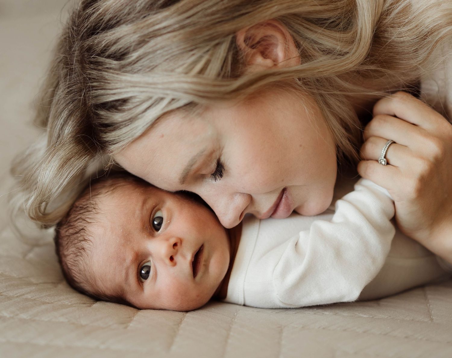 Mamma med dotter liggandes på säng