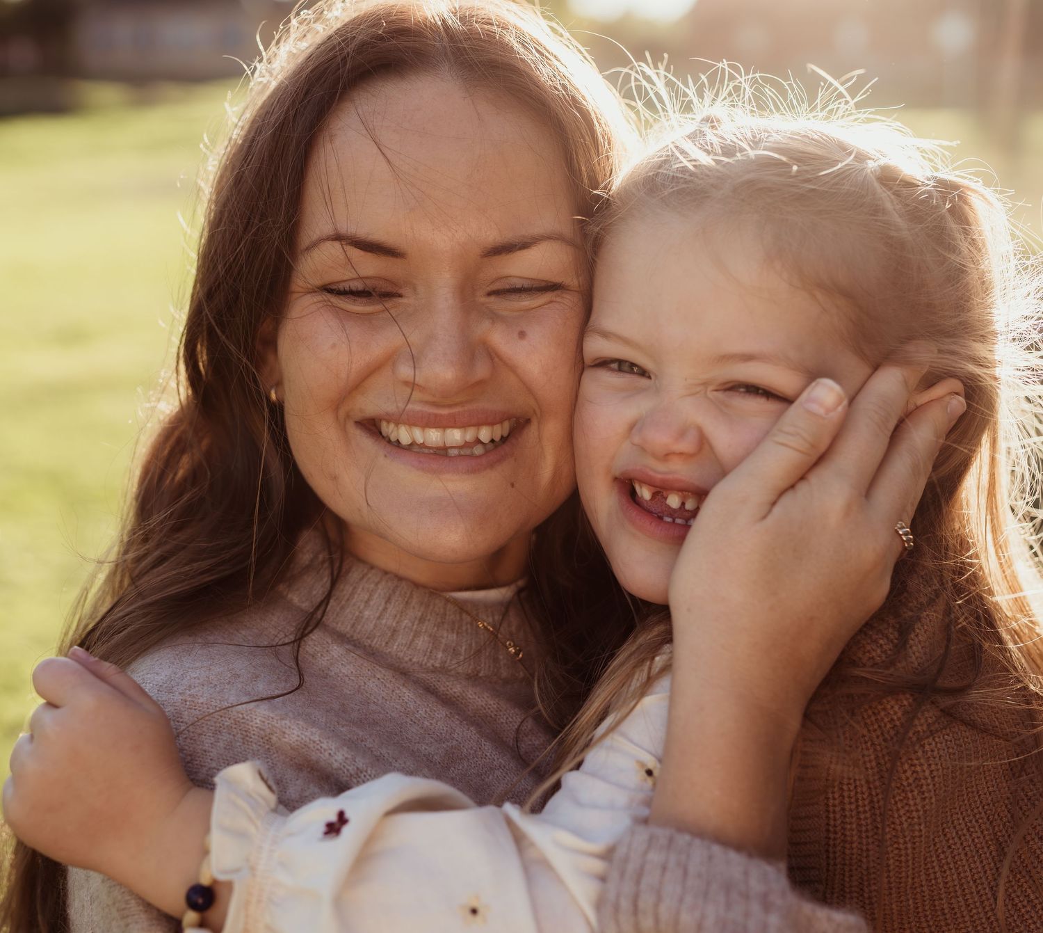 Glad mamma med dotter kind mot kind.