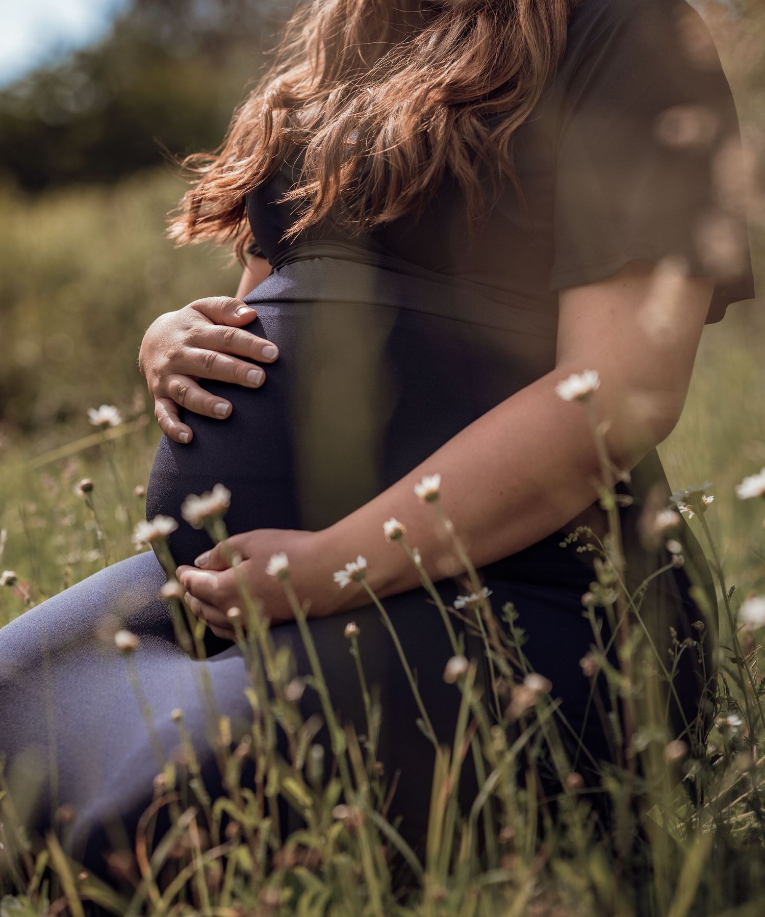 Gravid mage på en blomsteräng