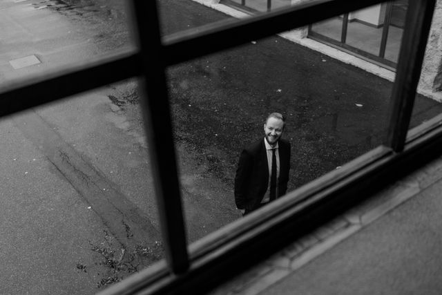 A man in a suit seen from above through a large window