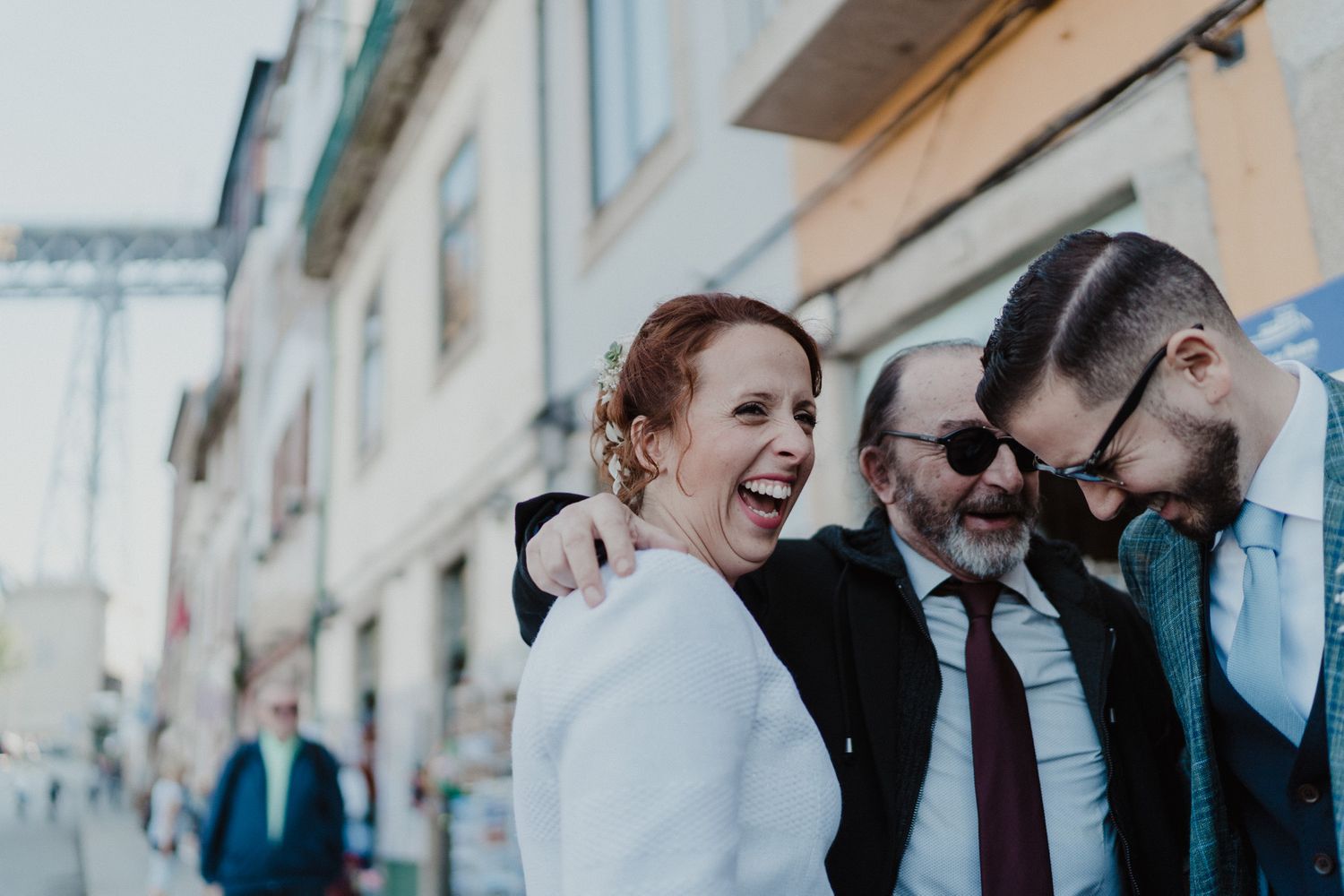 Bride and groom laughing with friends during a Porto wedding