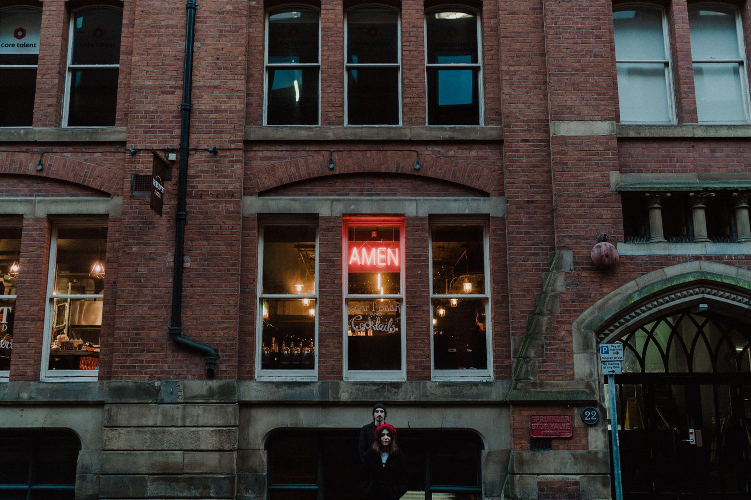 Red-brick building with lit windows at dusk