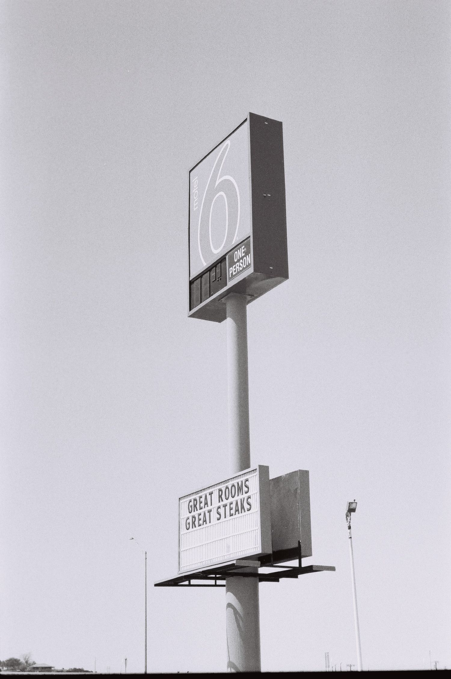 Tall roadside sign against a pale sky