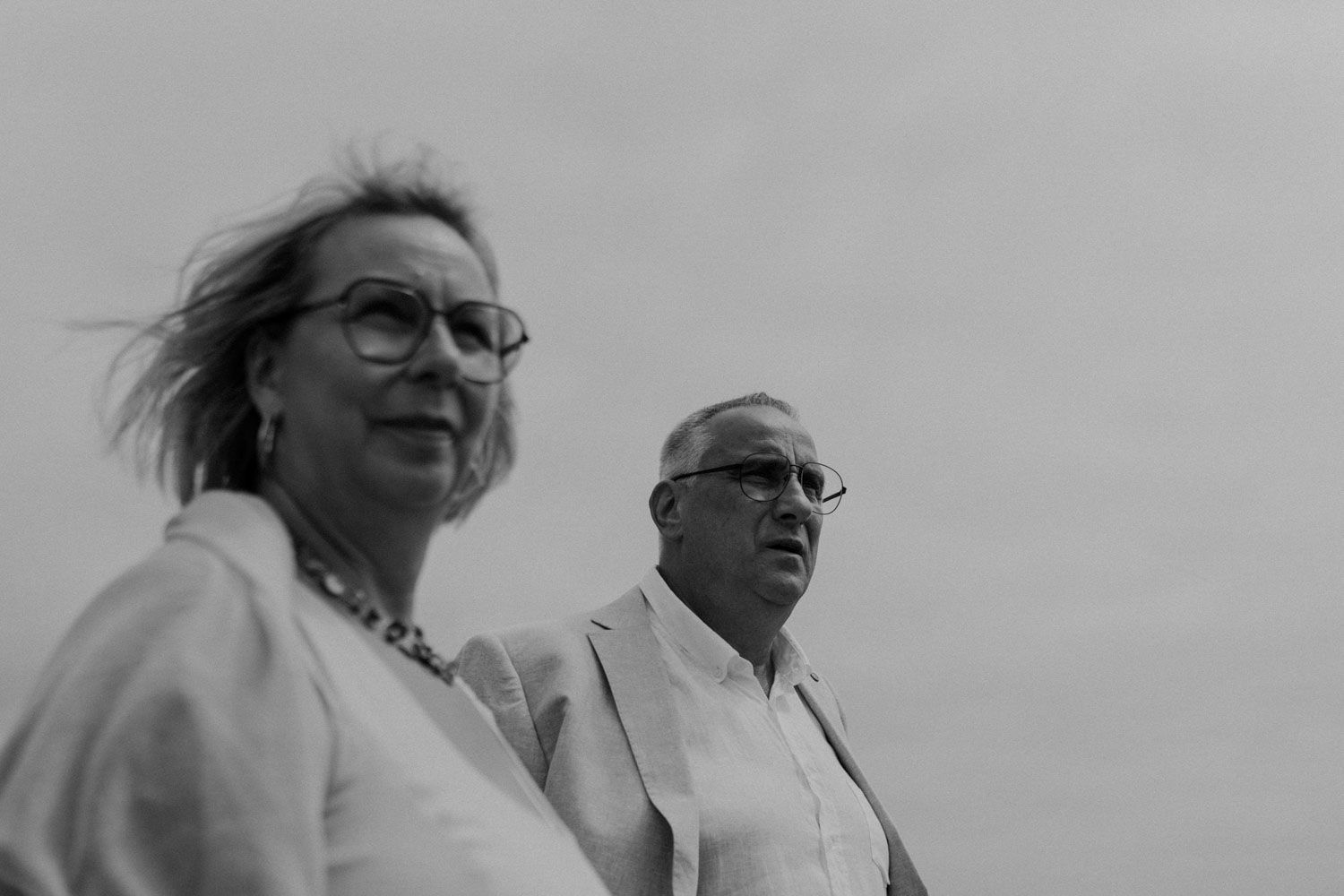groom walks with his parents towards the beach at Set Lounge, Portugal. German-style destination wedding cinematic photography