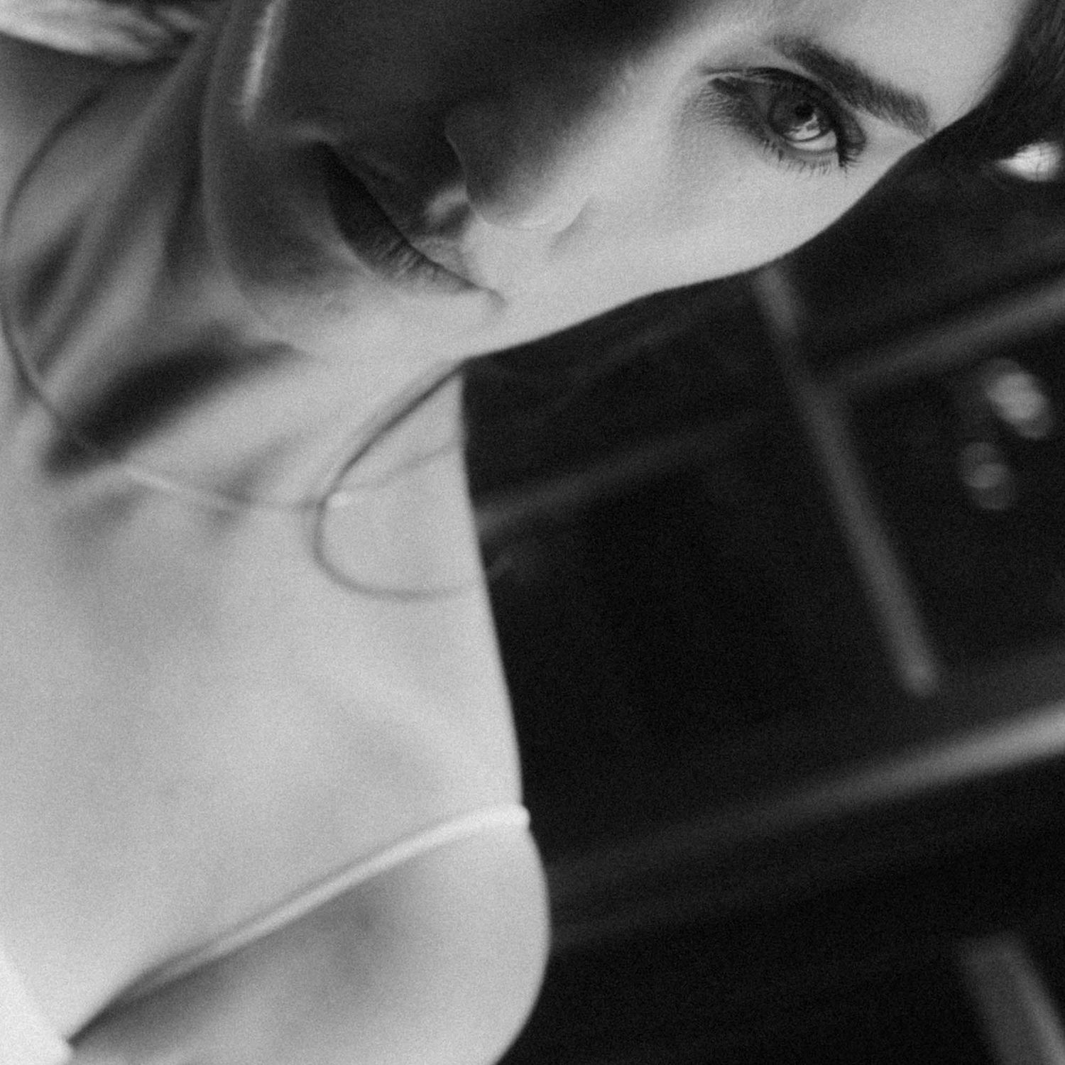 Black and white close-up of a woman looking downward.