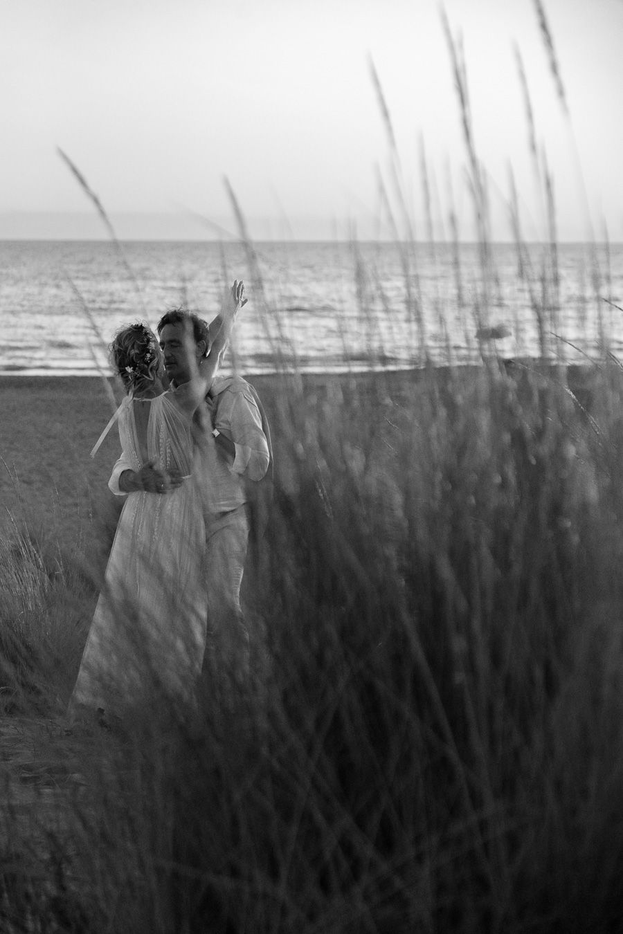 Wedding couple walking through the dunes on the Tuscan coast, Italy