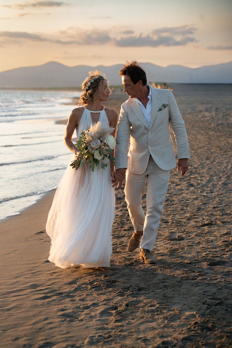 Wedding couple by the sea at sunset on the Tuscan coast, Italy