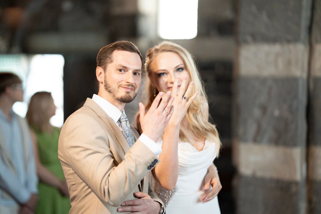 Newlywed couple showing wedding rings after the ceremony