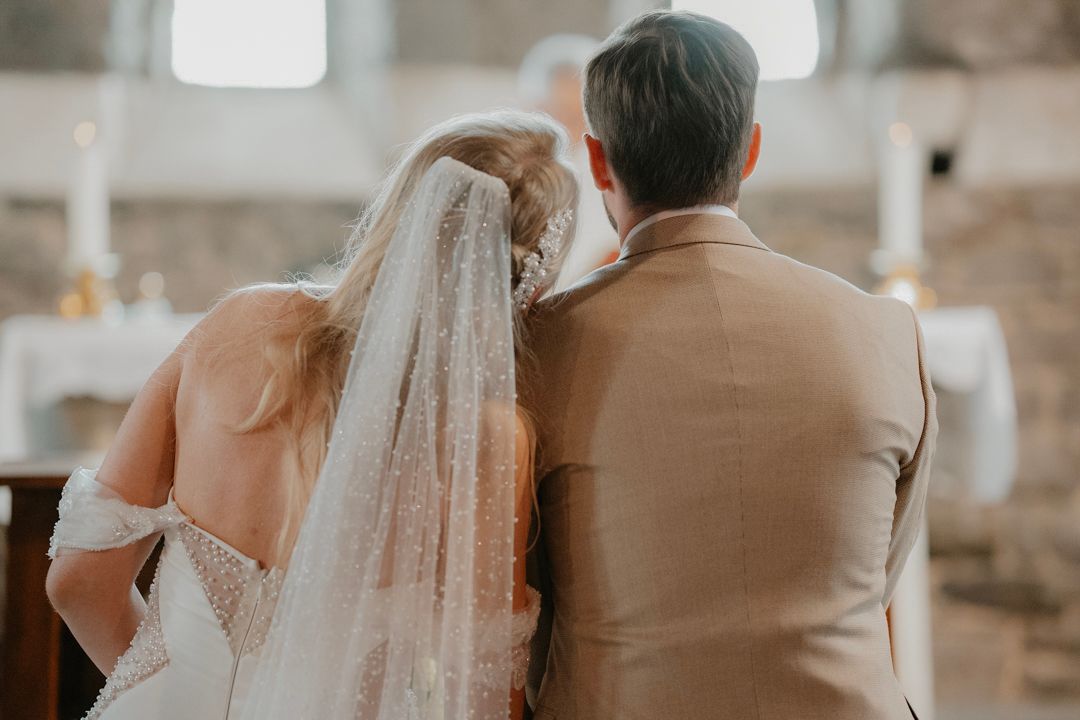 Wedding couple photographed from behind during the church ceremony