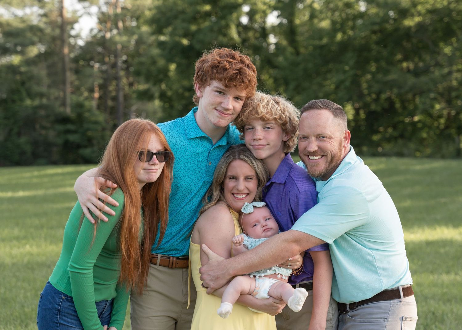 Family members hugging and laughing together outdoors in a series of candid photos on a sunny day in a park setting.