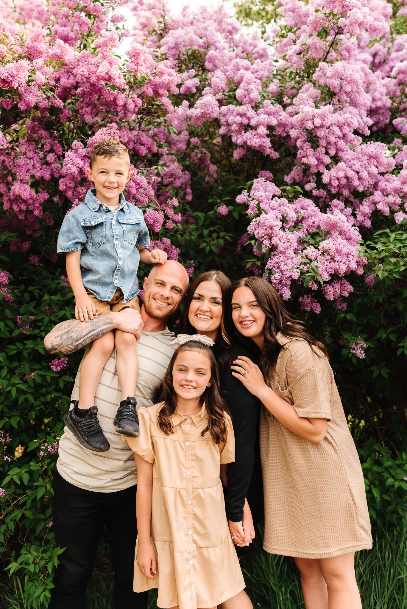 Joyful family gathering outdoors with pink flowering trees in the background.