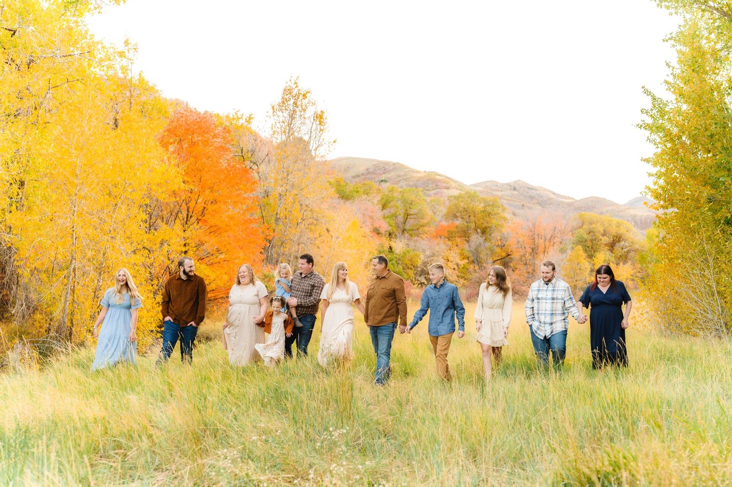 Large group photo in autumn field with golden aspen trees in background.