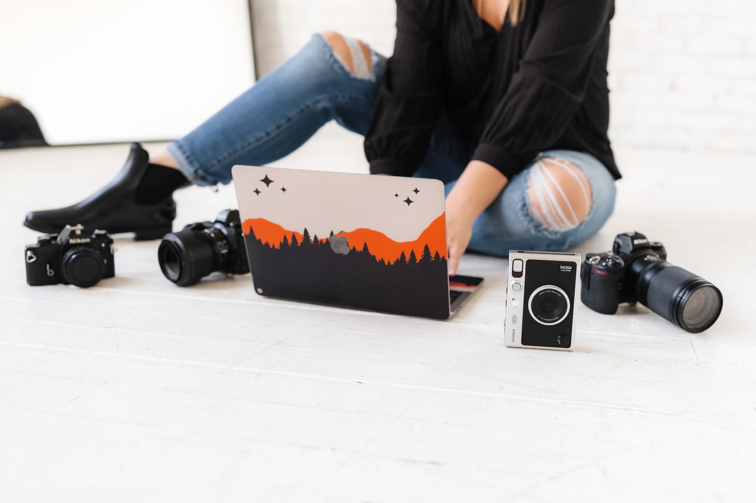 Photography equipment and gear laid out on white studio floor.