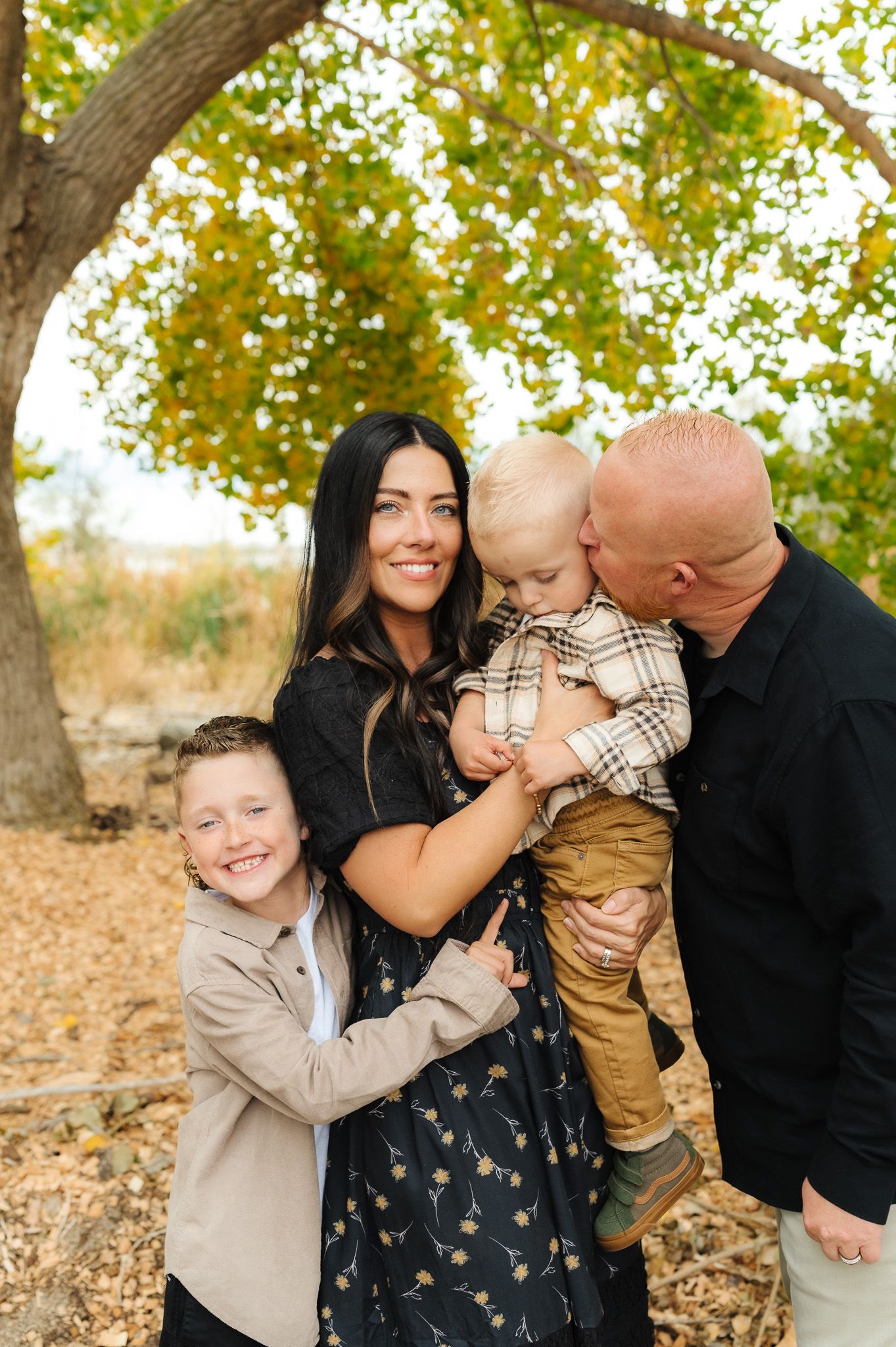 Candid family moments captured under fall foliage.