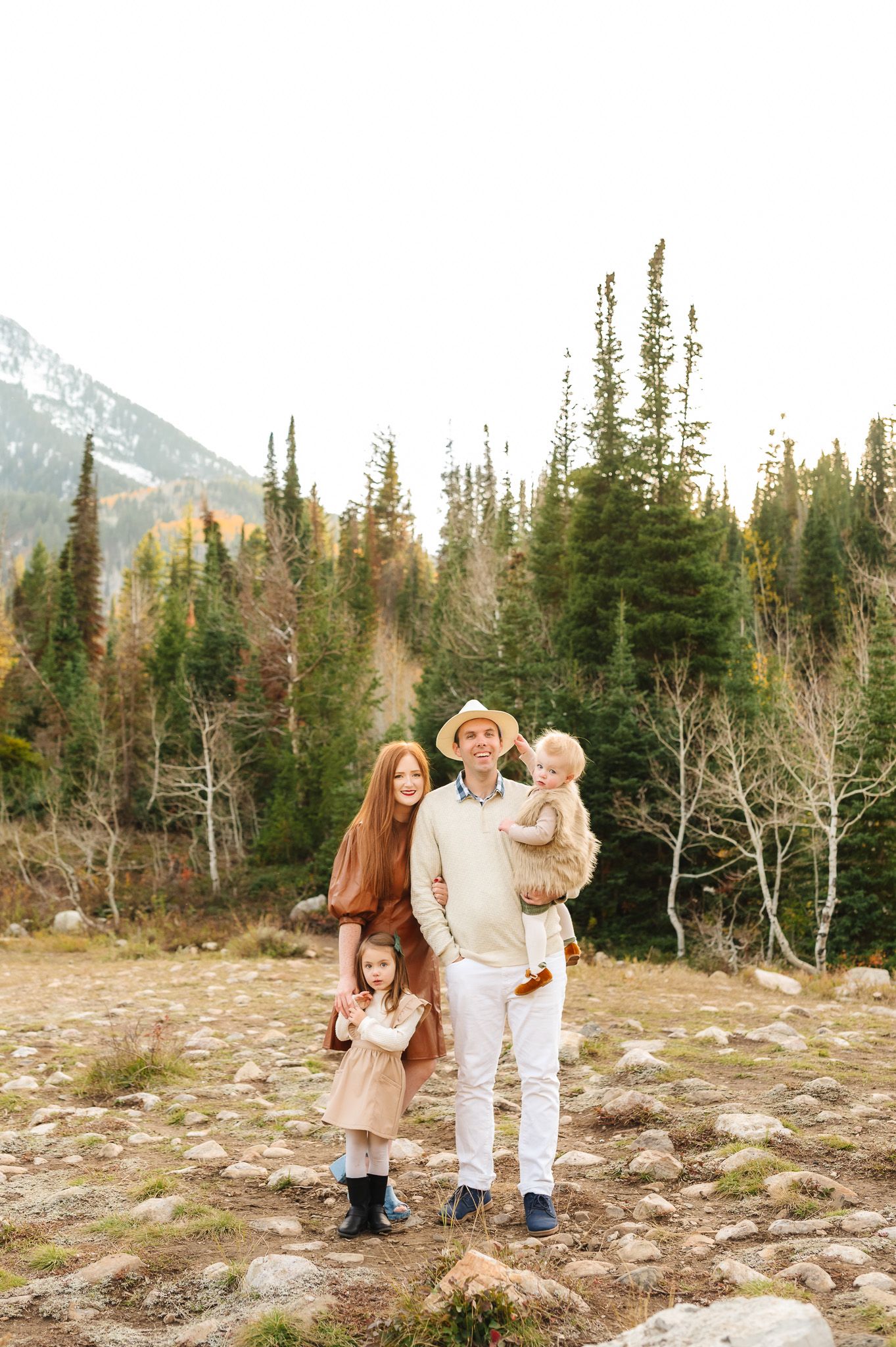Family walking together through rocky mountain terrain during golden hour.