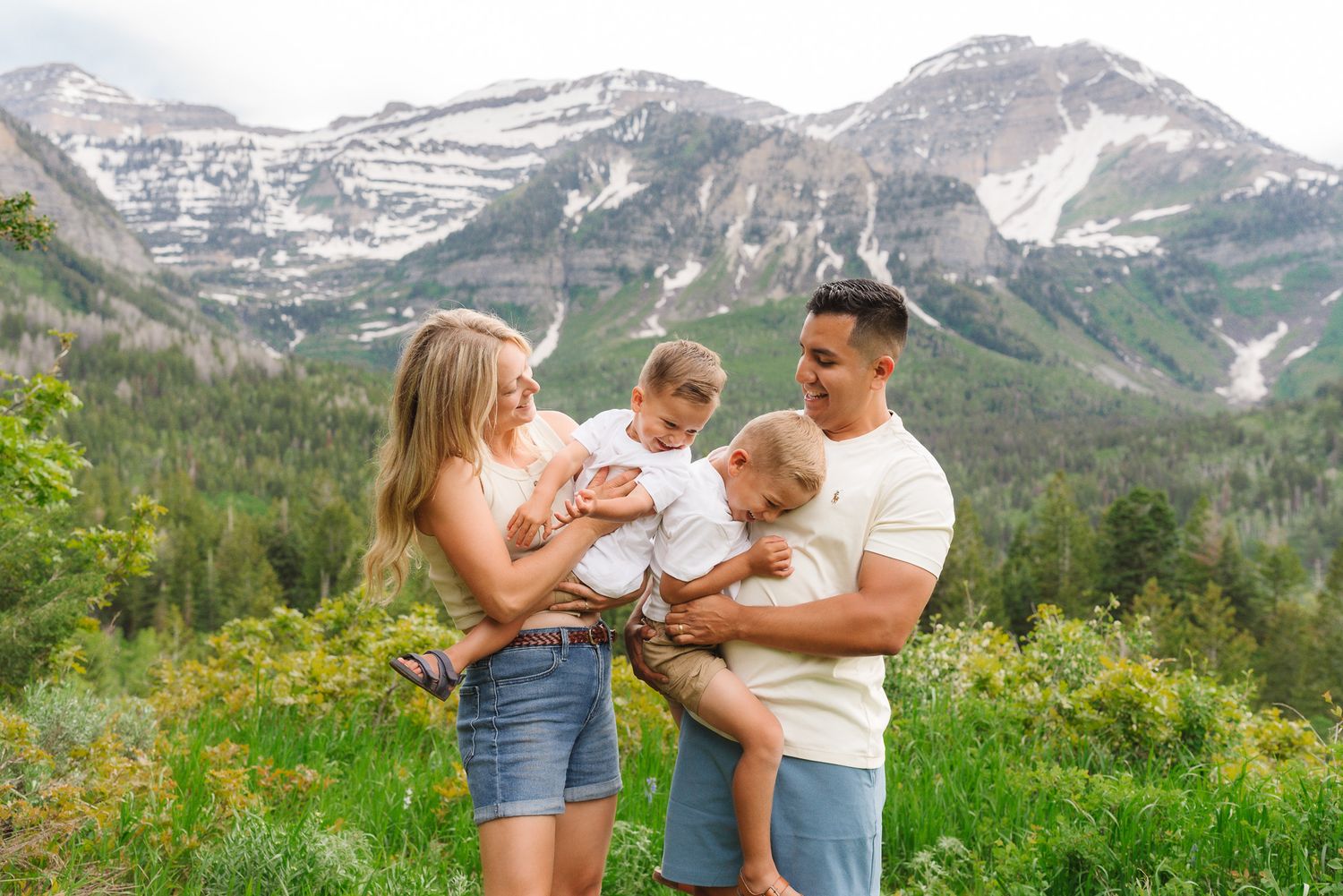 Family portrait session in a mountain meadow with dramatic peaks in the background.