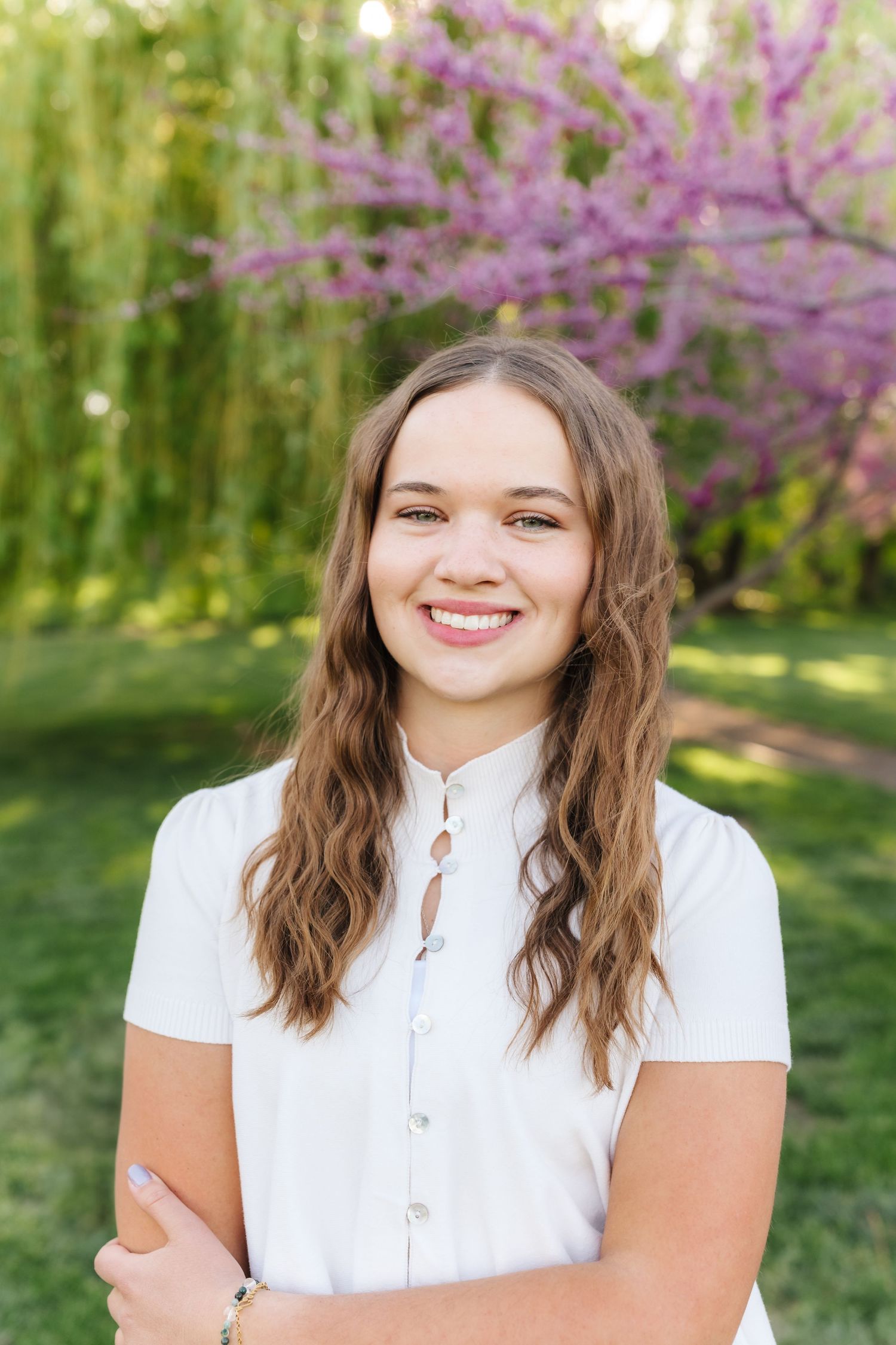 A series of outdoor portrait photos taken in front of blooming pink redbud trees in springtime.