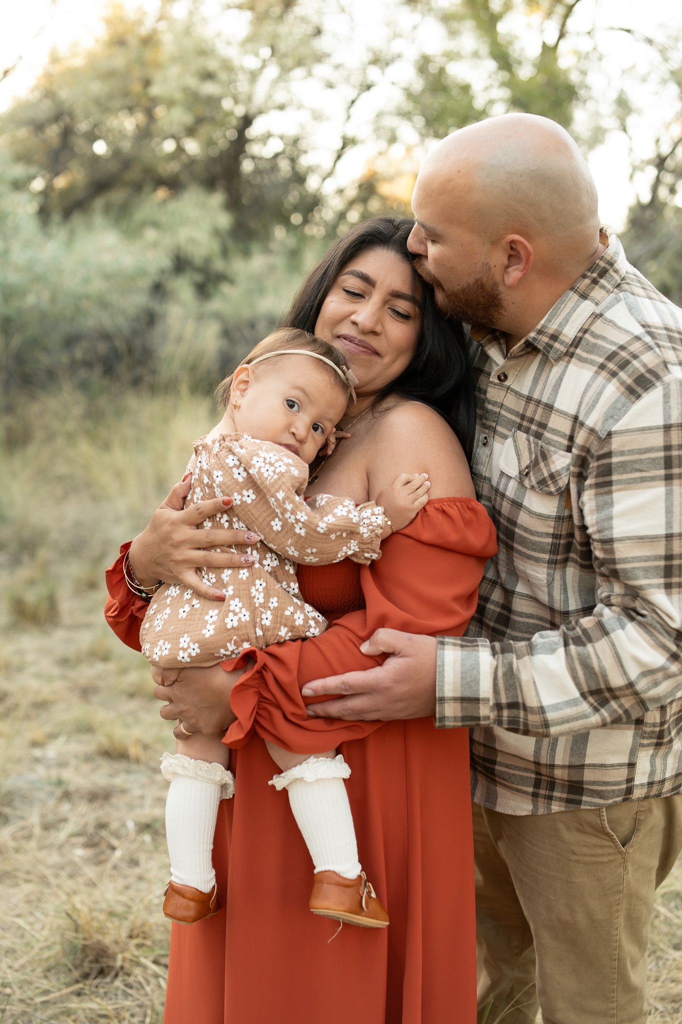 Natural outdoor family photography showing loving embraces against a soft natural background.
