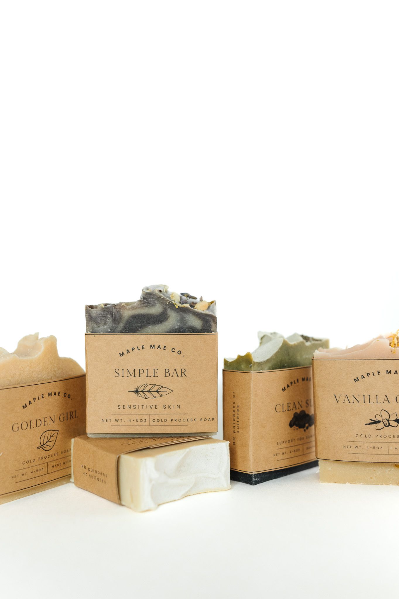 A row of vintage-style soap boxes with natural ingredients and earthy tones arranged in a panoramic display.