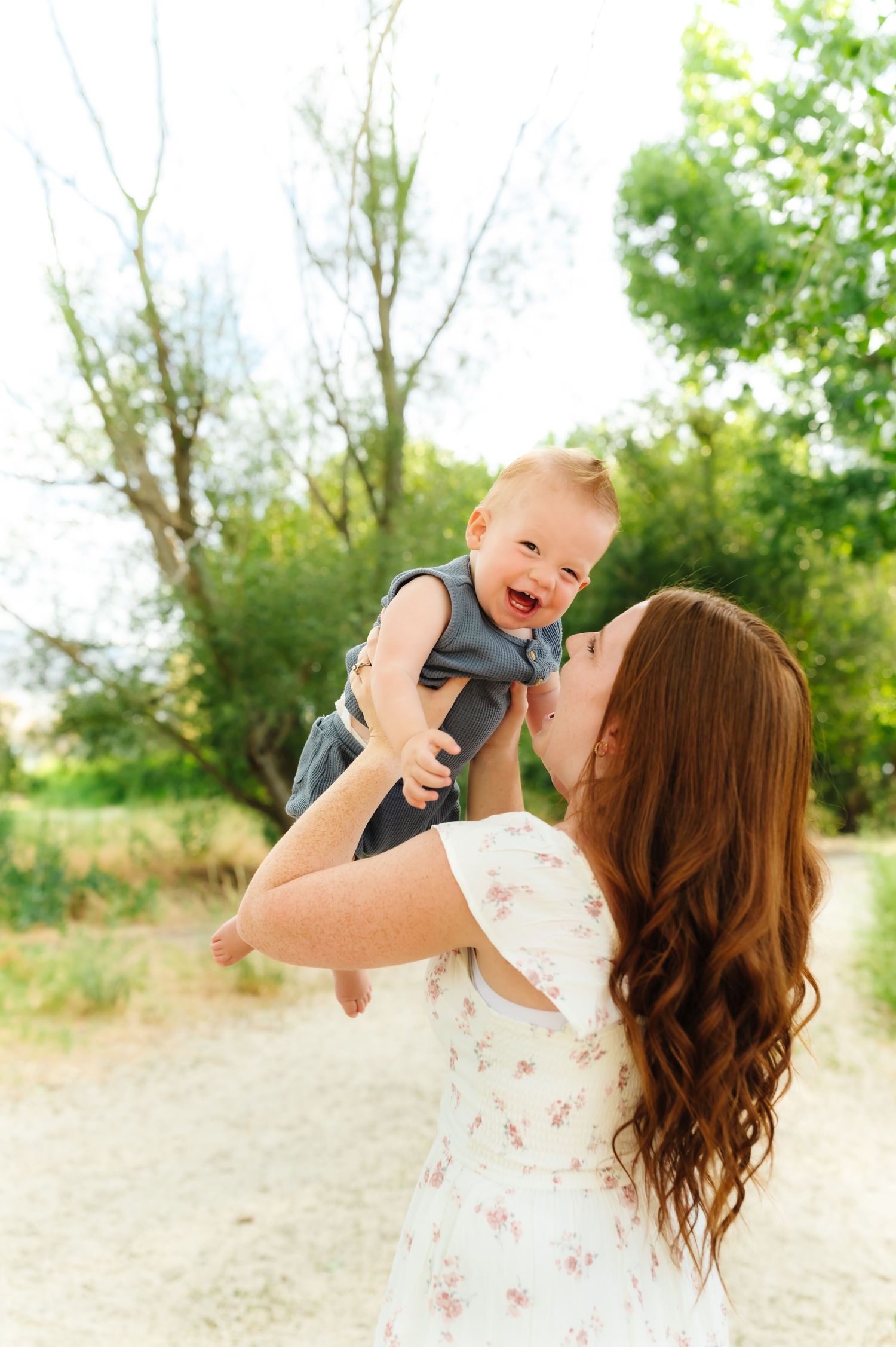 Joyful moment between parent and baby outdoors in natural setting.