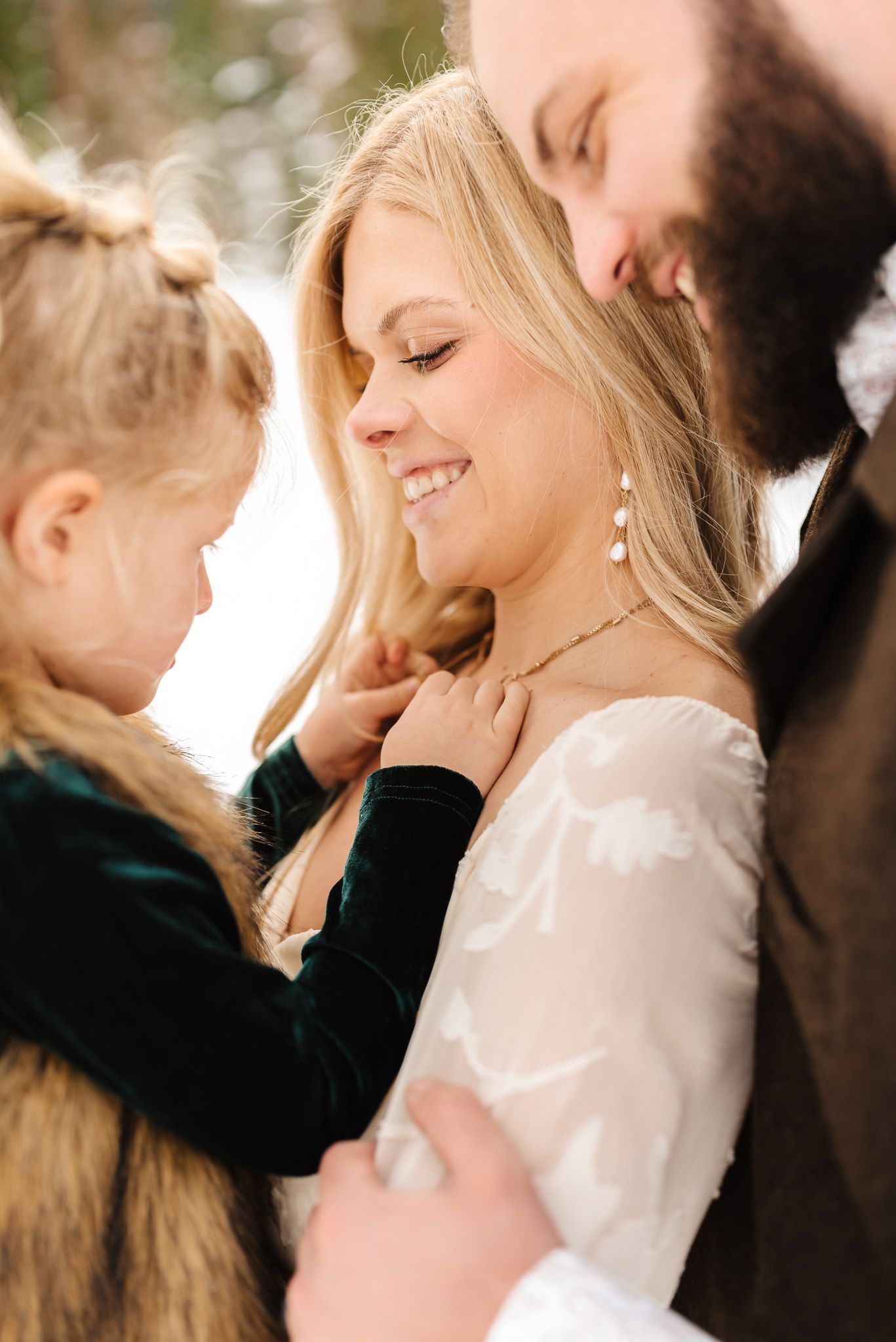 Intimate family portraits showing tender moments against a snowy forest backdrop.