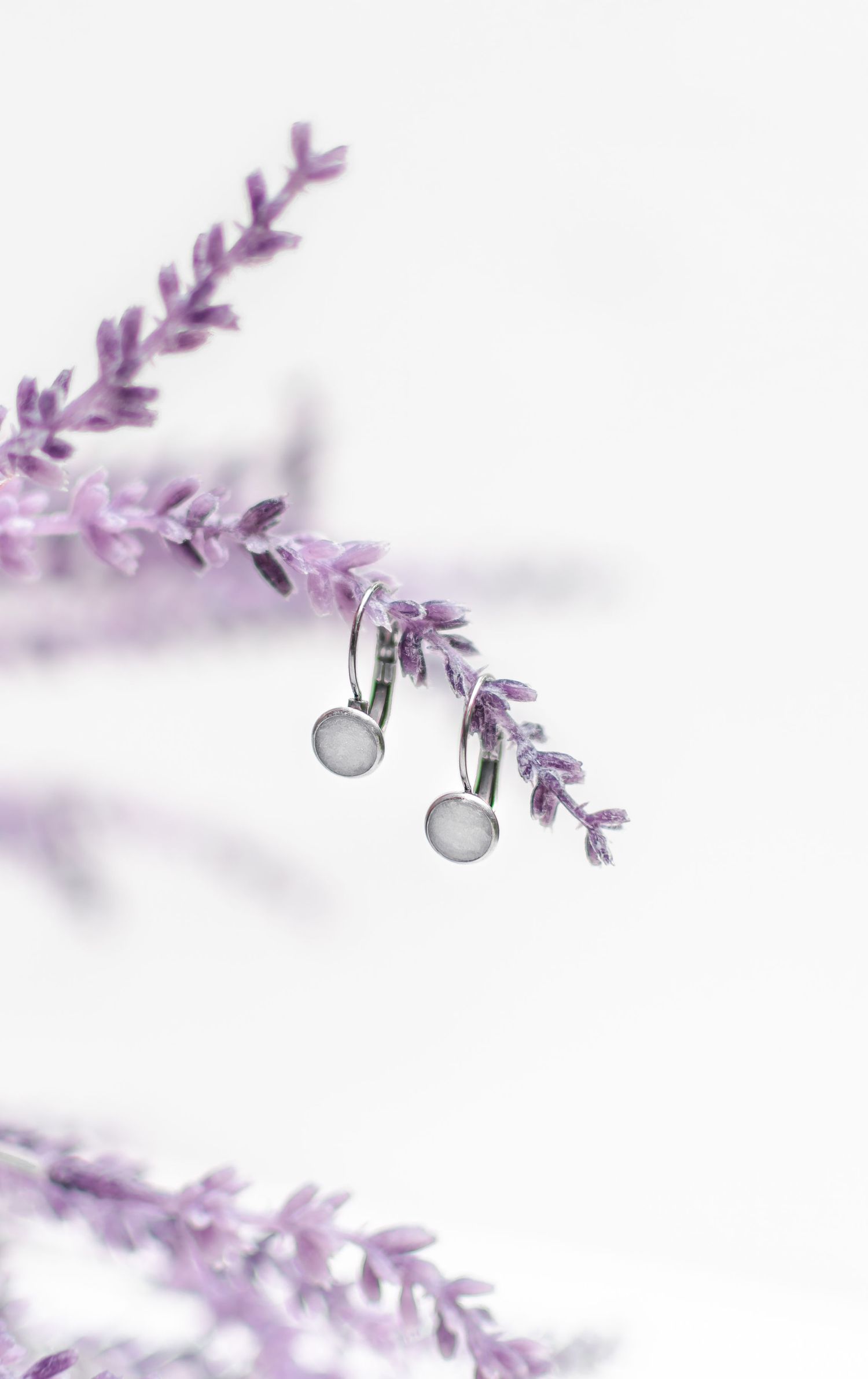 Delicate purple lavender sprig with silver jewelry pieces attached.