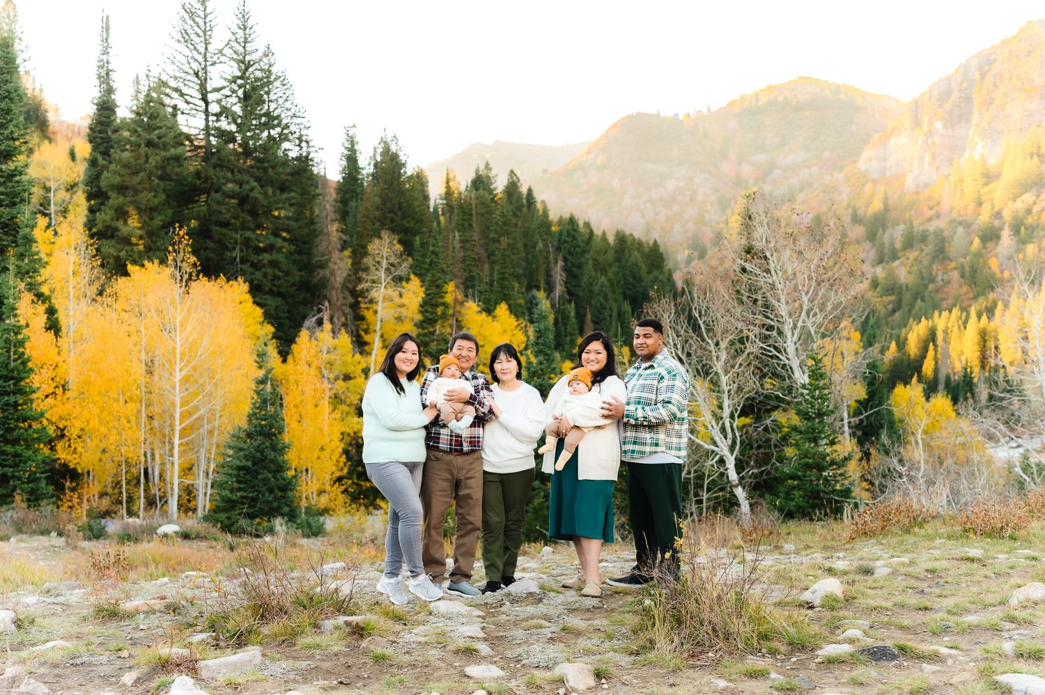 Extended family gathering for photos in an autumn mountain setting with golden aspens.