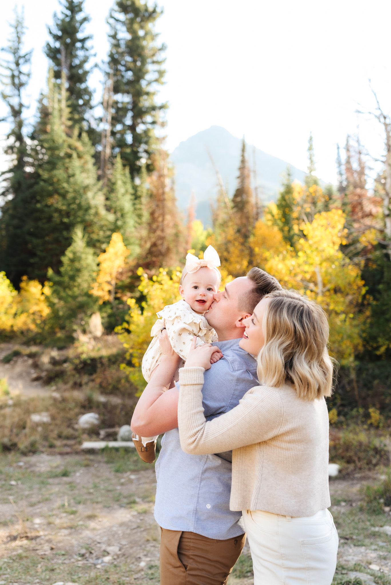 Family members sharing loving embraces against a backdrop of fall mountain scenery.