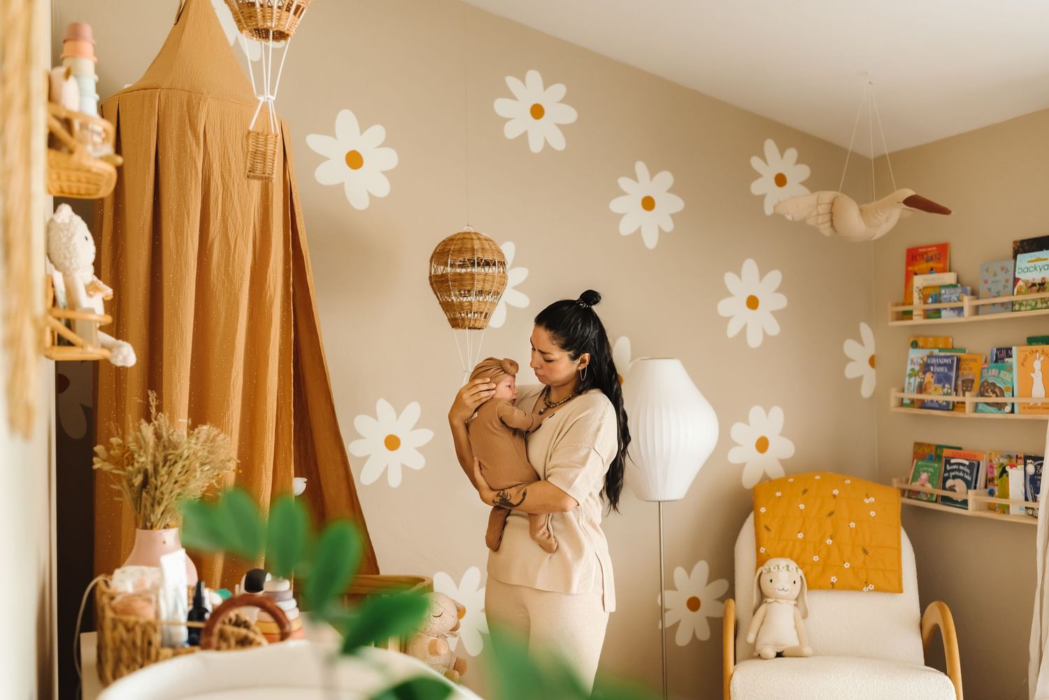 Whimsical nursery with daisy wall decals and hot air balloon decorations.