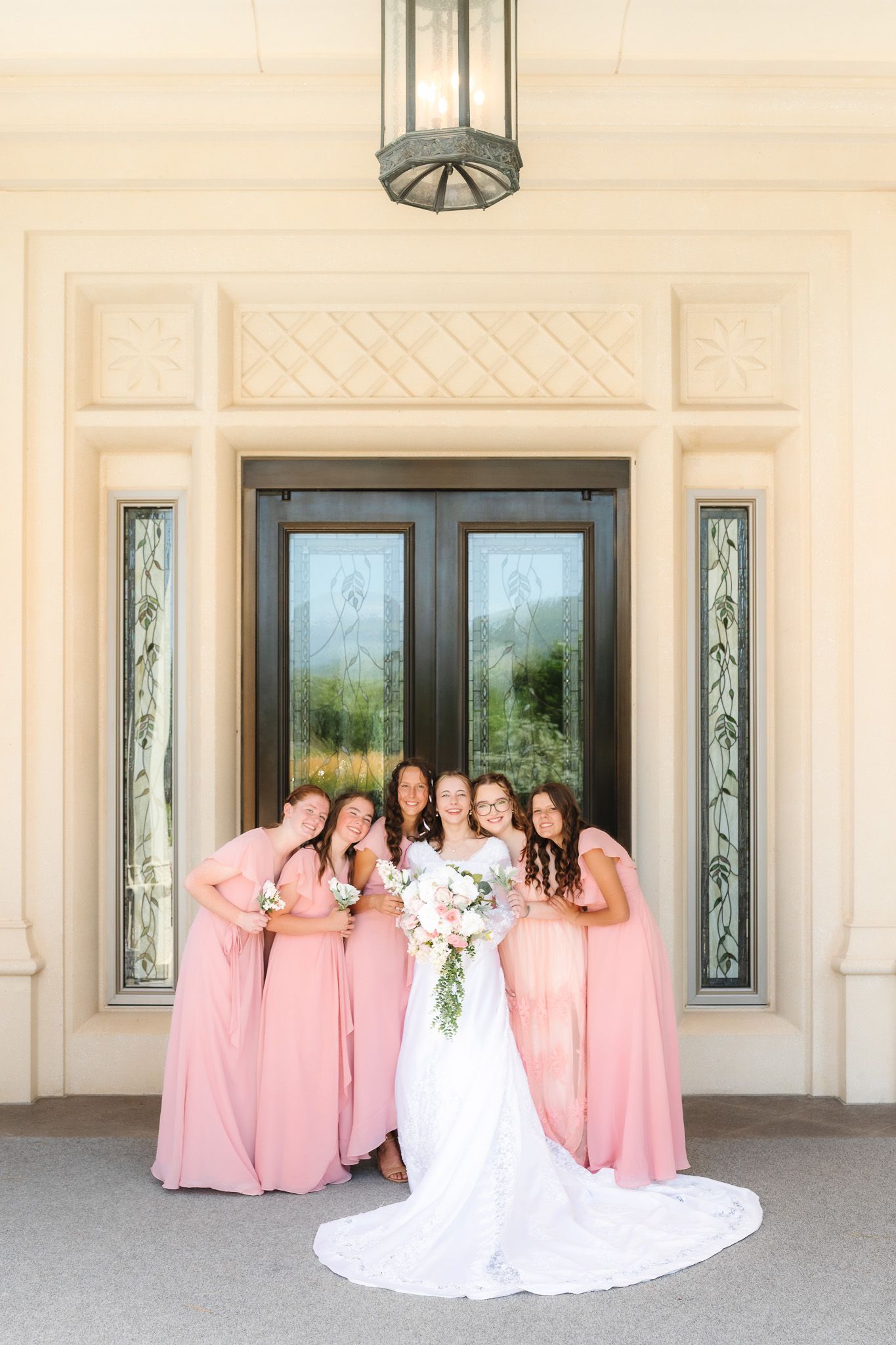 A bride in white gown poses with bridesmaids wearing pink dresses in a series of playful photos on a porch.