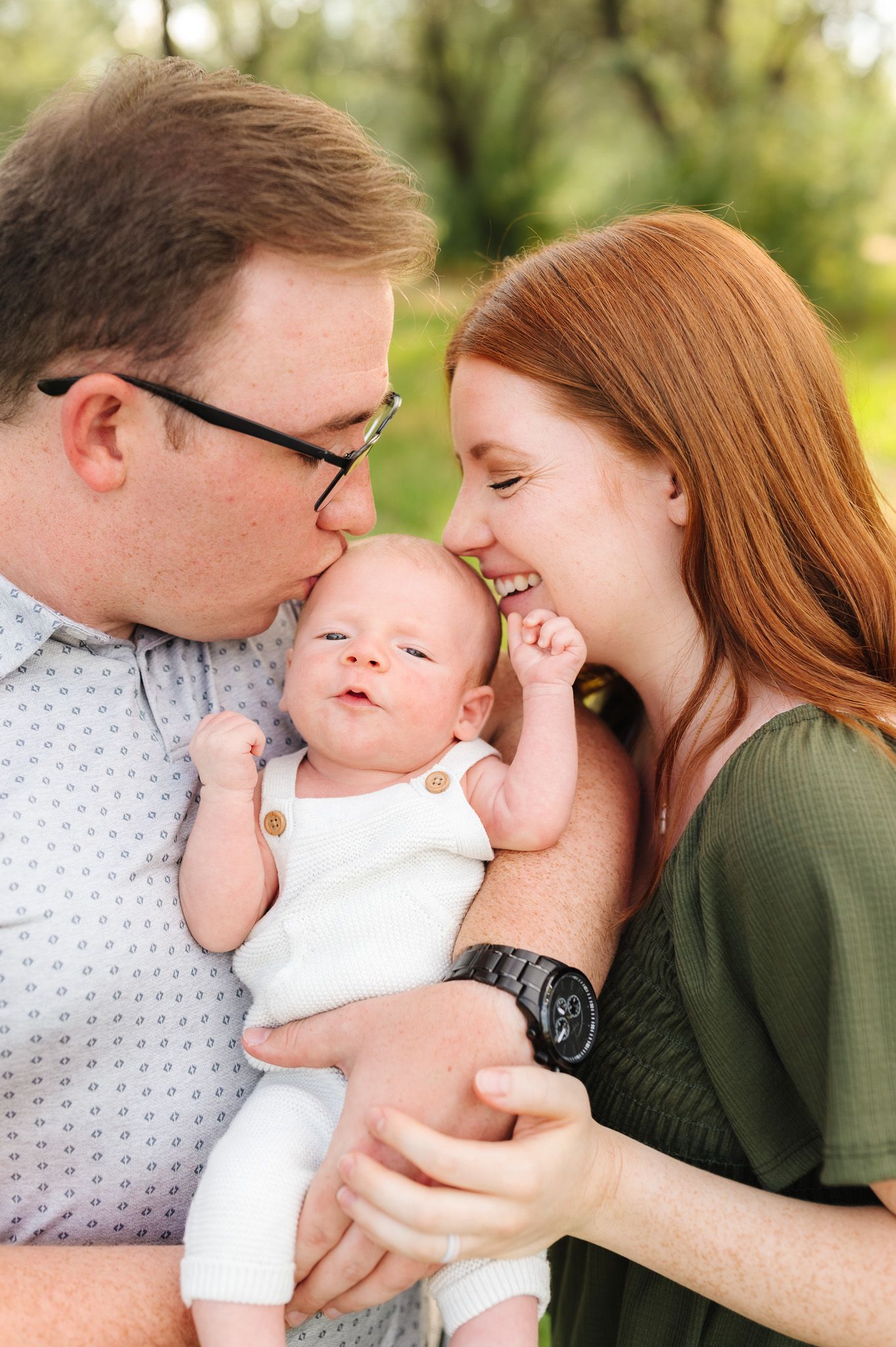 A tender family moment with a newborn baby outdoors in natural lighting.